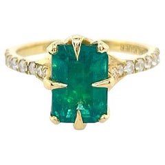 2ct Emerald solitaire ring with diamonds set in 18ct yellow gold