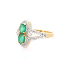 Magnífica alianza de dos esmeraldas con halo de diamantes en oro amarillo de 18 quilates