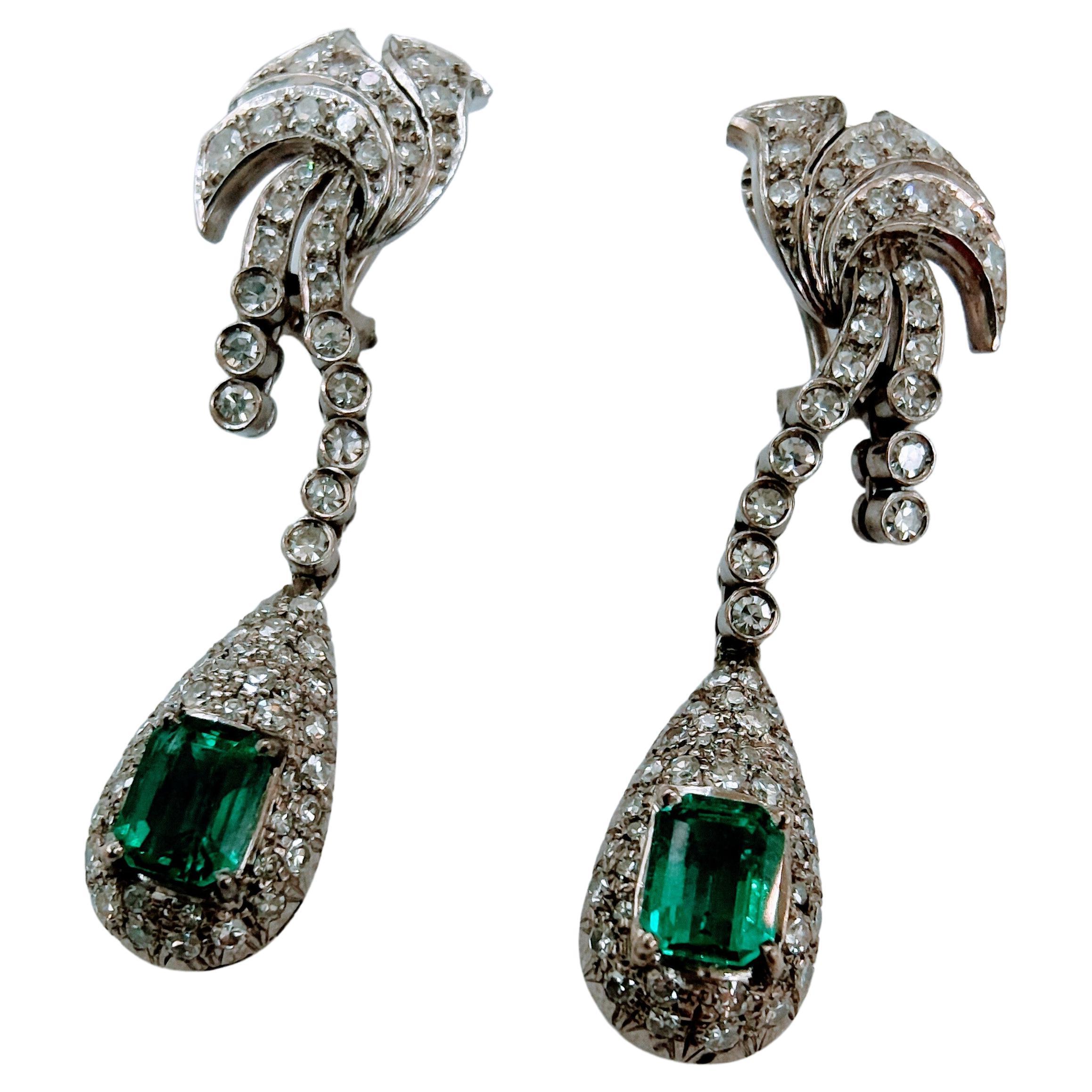 Impressive earrings art-deco with omega system long and waterfall shape. Made White Gold 18 Karats weight 12.7 grams. The Colombian Emeralds of beautiful color and transparency of 6.70 x 5.00x 4.30mm = 2.10 total carats the pair and Diamond Curd
