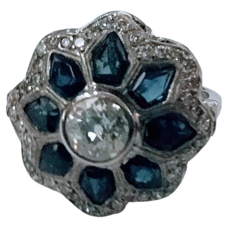 Art-Deco ring make in Platinum weight 7.62 grams with central Diamond antique cut color I-H Clarity SI1-P1 weight 0.85 carats and around by 10 sapphires form trapezoid staggered cut total weight 3 carats and 45 Diamonds in brilliant cut total weight