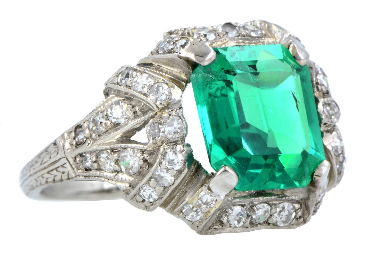 Art Deco Emerald & Diamond Ring centering an Emerald cut emerald weighing app. 2.15ct., framed by 48 Single cut diamonds weighing app. 0.62ctw., in an open work, geometric design, fashioned in platinum. Circa 1930. Size 5.5