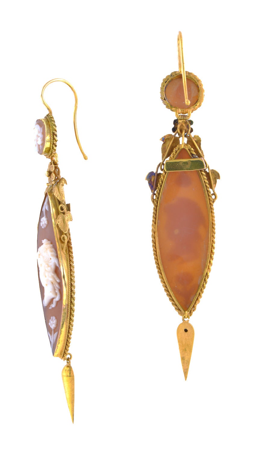 Georgian Shell Cameo Drop Earrings with navette shaped drops featuring classical women in profile, suspended from round cameo tops, with flower and leaf details, fashioned in 18k. Circa 1830. Length 3 inches (including ear wires)