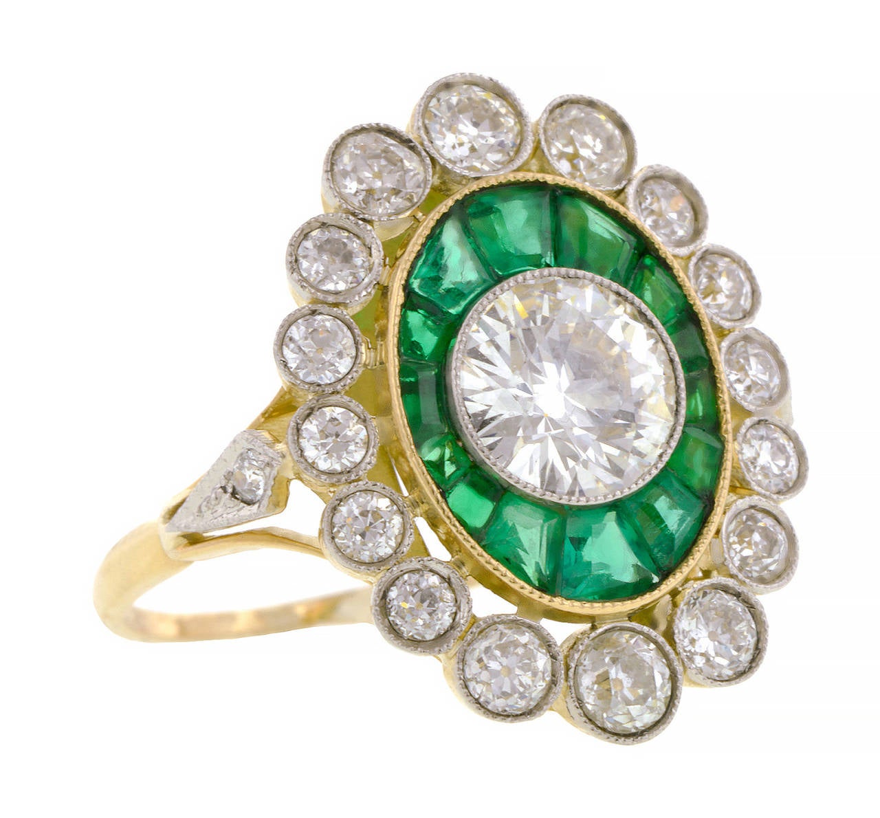 Diamond & Emerald Frame Ring centering a Transitional Round Brilliant cut diamond weighing app. 1.03ct. (G-H color, VS2 clarity), framed by calibre cut emeralds measuring app. 1.5 - 2.5 x 3.0mm. and an outer frame of bezel set Old European cut