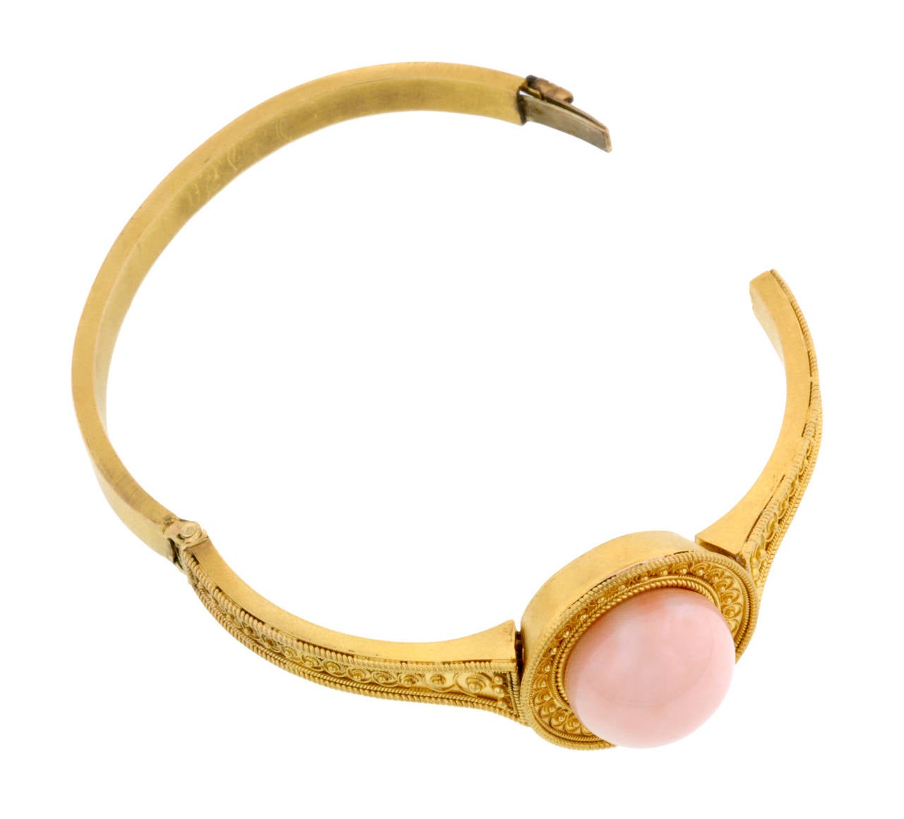 Victorian Etruscan Revival coral bracelet featuring a round, pale pink, Angel Skin, coral measuring app. 15.0mm in an Etruscan style bangle with granulation bead design, fashioned in 18k gold. Measures 6 inches on inside of bracelet. Circa 1870.