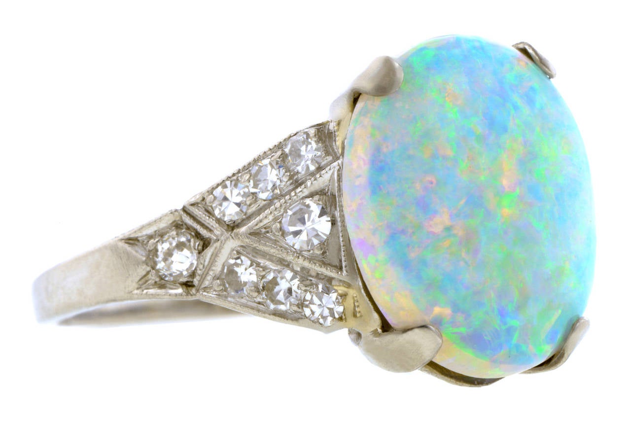 Art Deco opal & diamond ring centering an oval opal measuring app. 12.1 x 10.05mm and weighing app. 2.43ct., flanked by sixteen diamonds (1 Old European & 15 Single cuts), all weighing app. 0.30ctw., in a tapered double triangle design, fashioned in