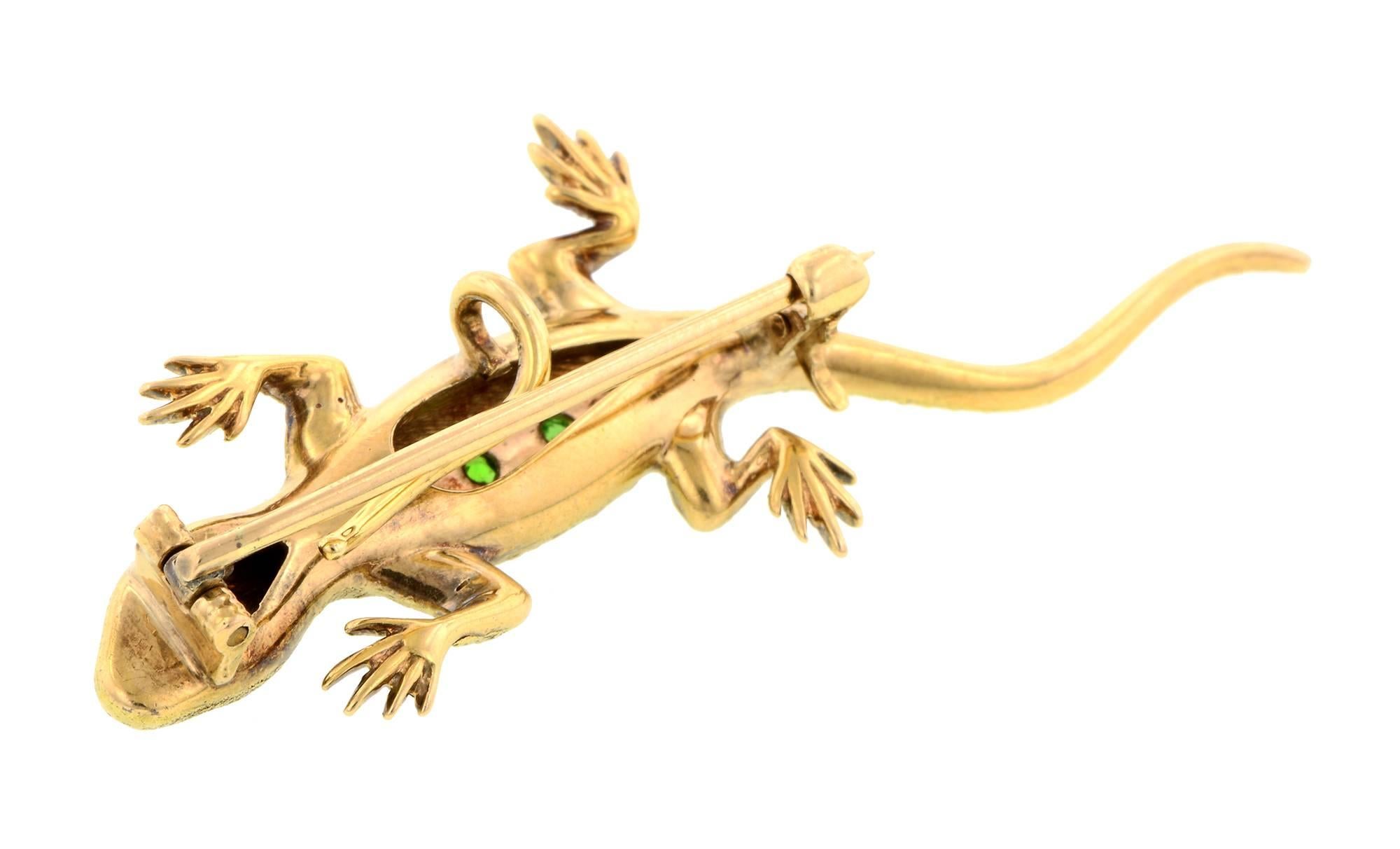 Antique demantoid garnet salamander pin measuring app. 2 x 3/4 inches, featuring seven demantoid garnets measuring app. 1.0 - 1.5mm and two Old European cut diamond eyes weighing app. 0.02ctw., in an engraved salamandar brooch, fashioned in 14k.