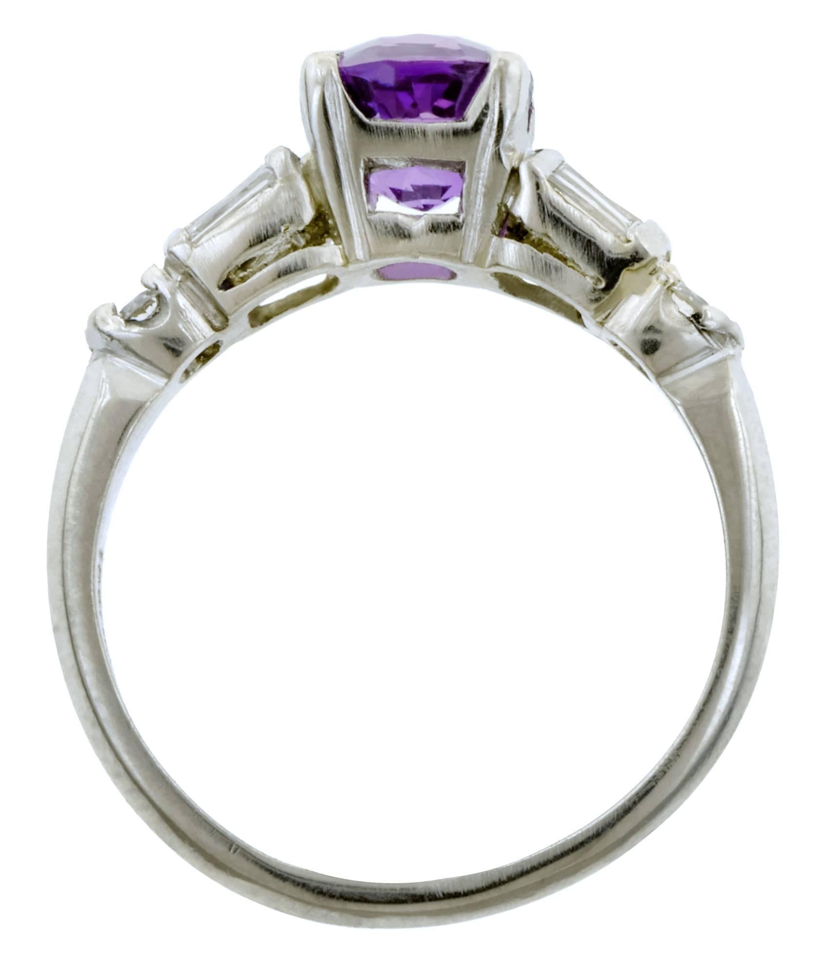 Vintage sapphire ring centering a Cushion cut pink-purple sapphire weighing app. 2.04ct, flanked by six Baguette cuts & two Round Brilliant cut diamonds weighing app. 0.66ctw., fashioned in platinum. Circa 1945. Size 7.