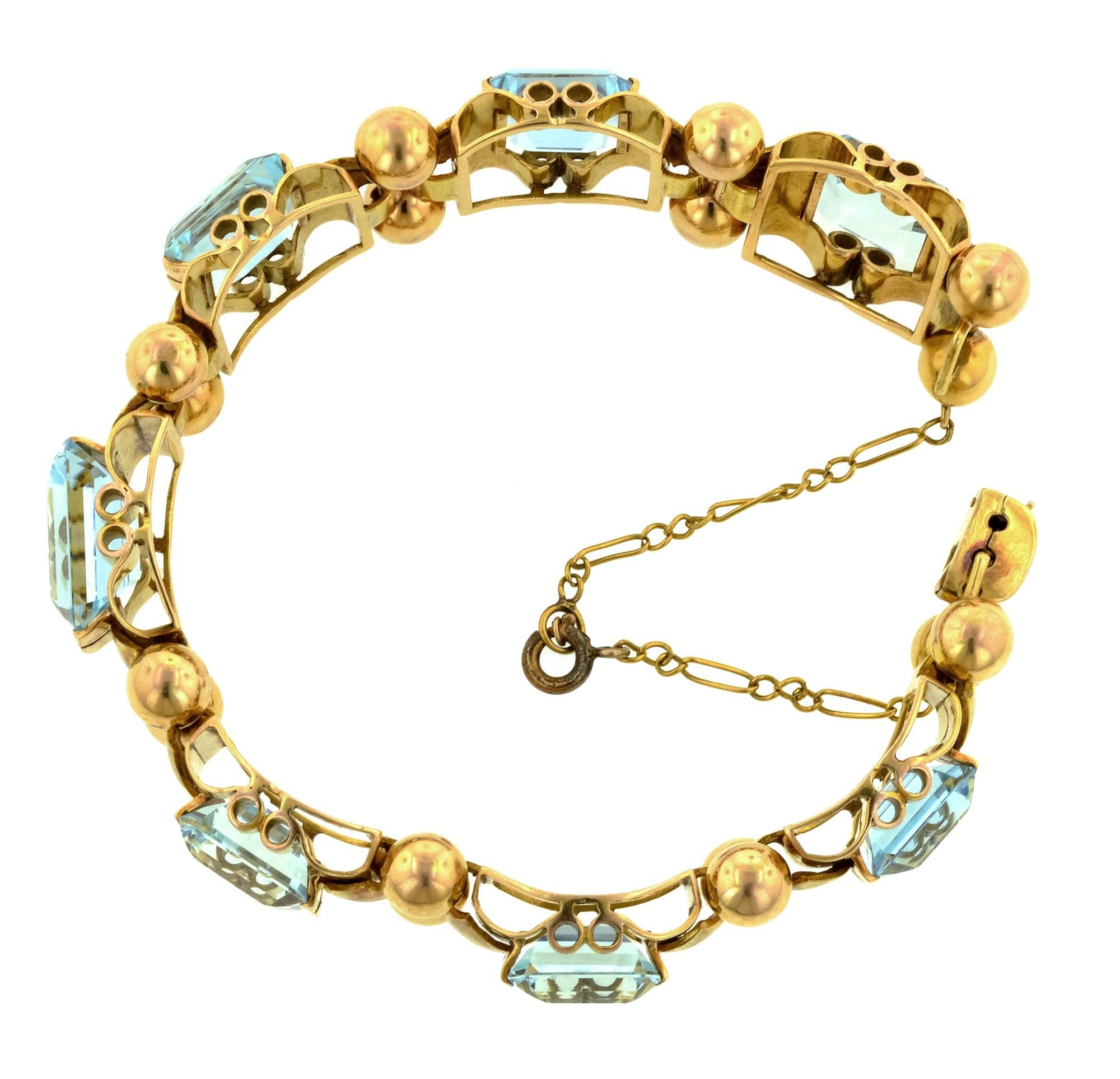 Retro aquamarine bracelet, app. 42.50ctw, measuring 7 9/16 inches in length and 9/16 inches wide; features seven graduating prong set rectangular step cut aquamarines with a combined approx. weight of 42.50ctw. Rolling fluted links with a hinged