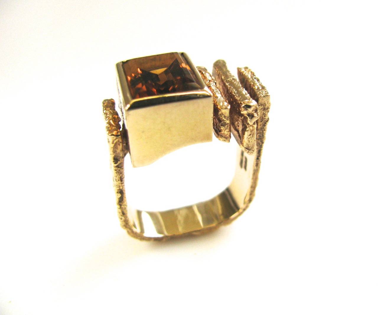 A handsome ring by Ole Lynggaard of Denmark. The 3/4" x 1/2" 14k textured yellow gold ring set with a rectangular shaped Madiera citrine in a polished box mount. A good-looking and easy to wear ring. Modernist and stylish.
Signed with