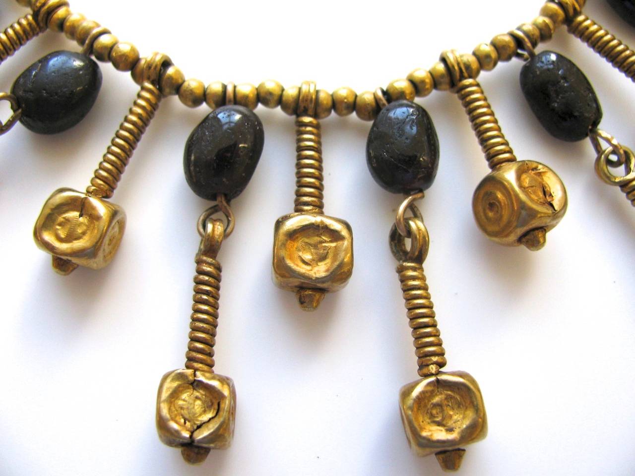 1970's ancient bead necklace by Patti Cadby Birch. The 22k yellow gold fringe necklace with gold and garnet beads on modern coiled wire-work with gold bead spacers. Birch, a collector, connoisseur and philanthropist moved to the Virgin Islands where