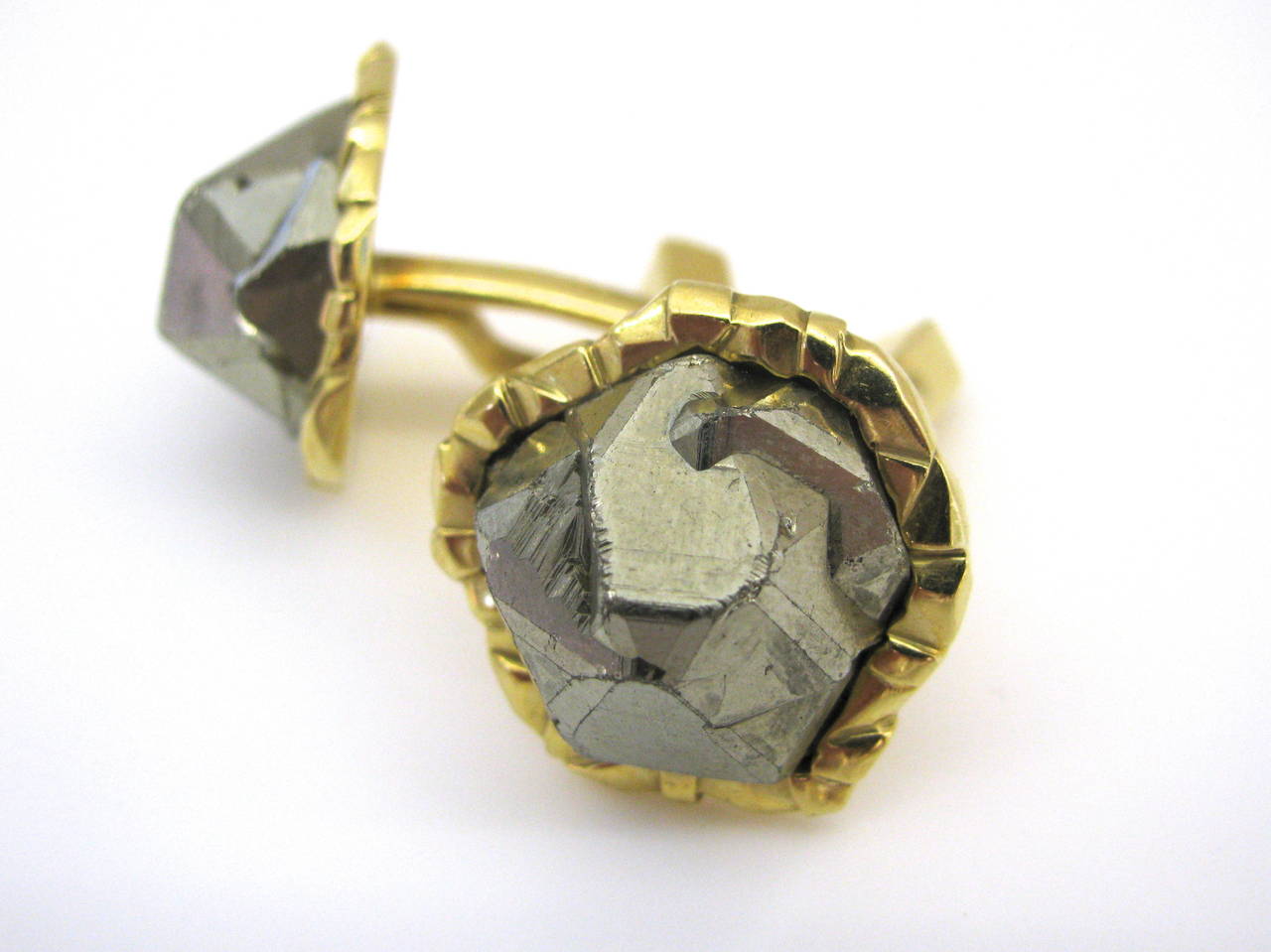 A unique pair of Cartier Cufflinks. The 18k yellow gold mounts with luminous natural P yrite nuggets. Pyrite, often called fools gold , for its mistaken gold-like glitter, has numerous meanings in love, lust and money. A great "tongue and