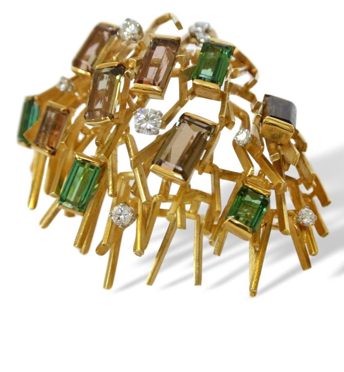 An early Geometric Brooch by Andrew Grima. The 18k yellow gold brooch with multiple gold rods, rectangular-cut green and & watermelon tourmaline, accented with round white diamonds. A chic and stylish brooch by master artist jeweler Andrew