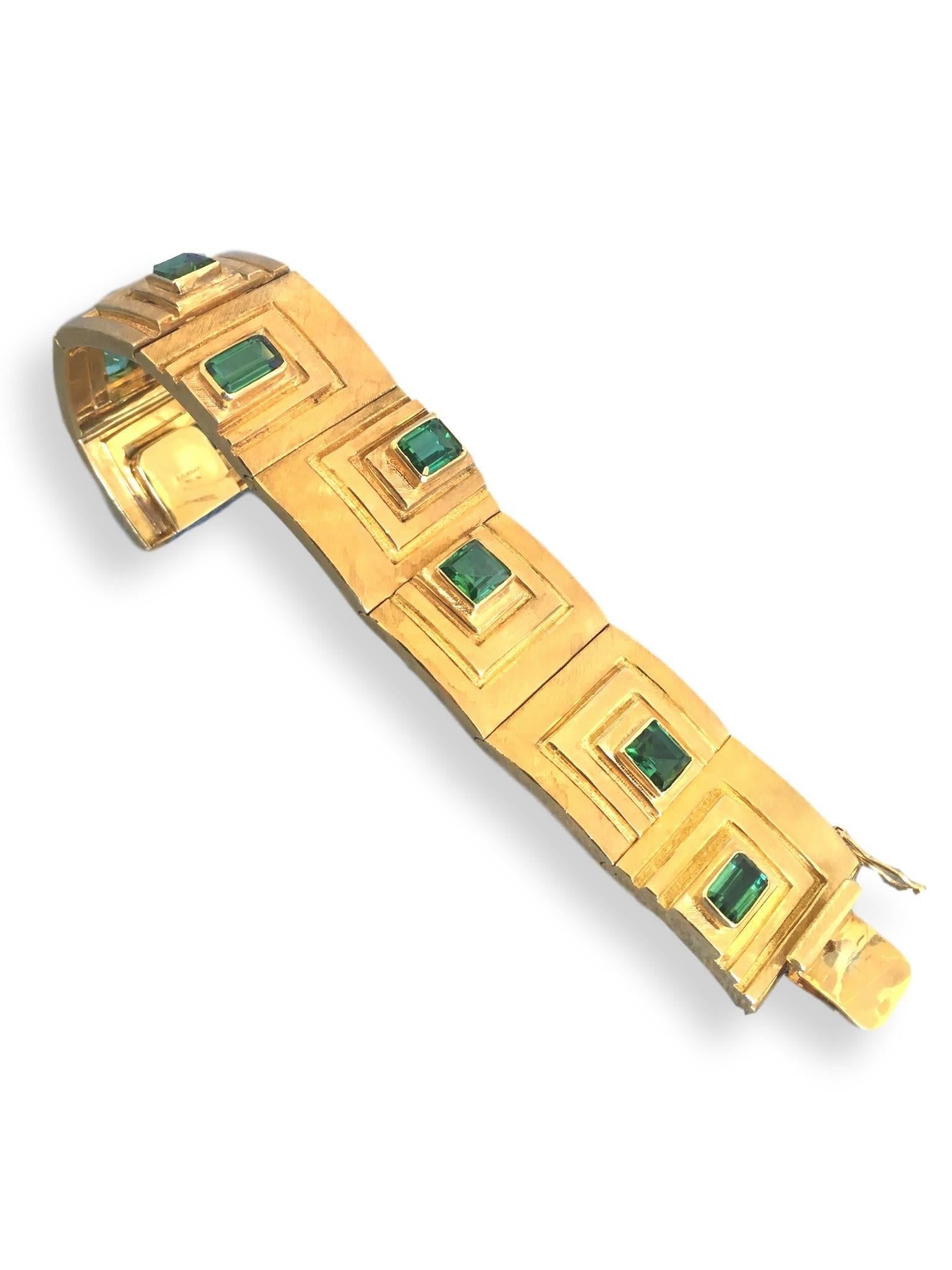 Modernist yellow gold bracelet by Burle Marx. The 1" w geometric plaque bracelet in 18k yellow gold with square and emerald -cut green tourmalines that are transparent, brilliant, and clean, with attractive bluish green hues.The Mesa design
