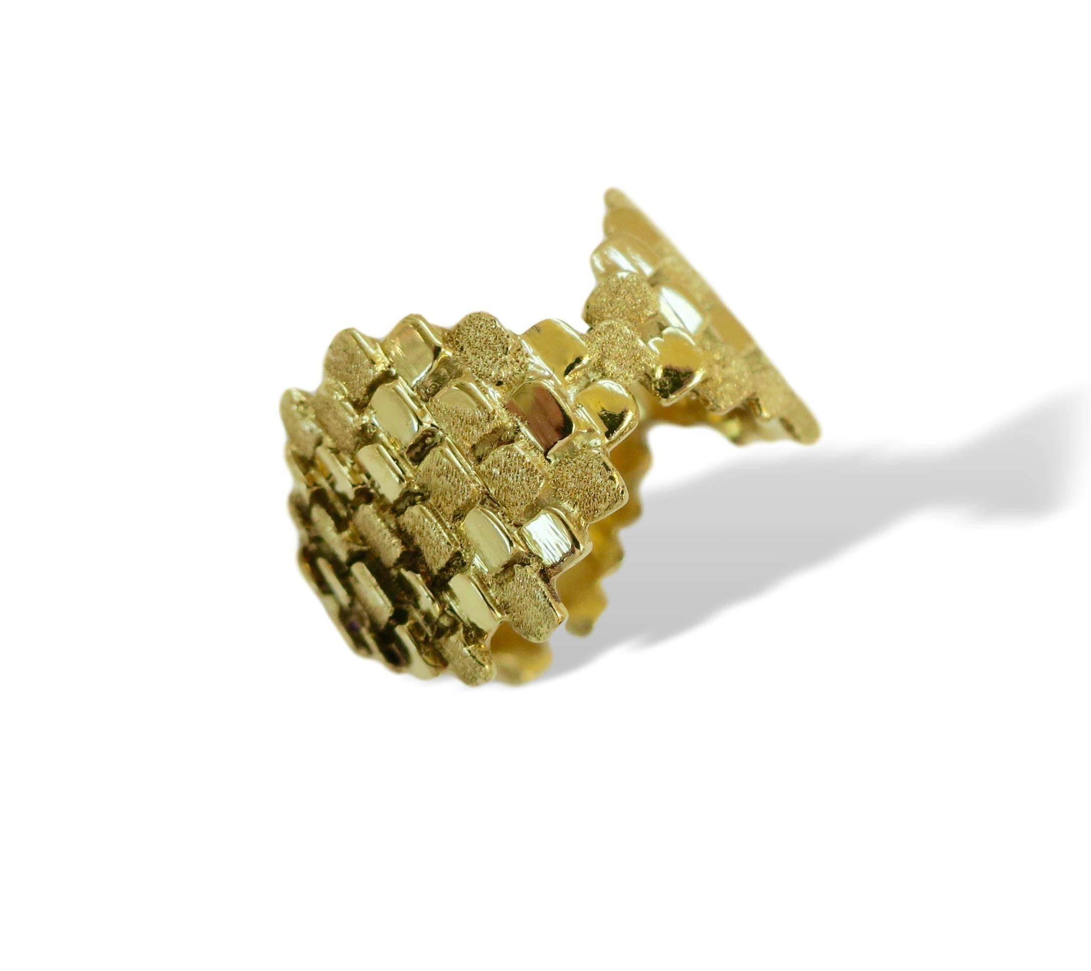 Modernist ring by designer Charles de Temple. The 18k yellow gold band made up of textured and polished square elements stacked to create an arrangement of three diamond-shaped components to form a band ring.
De Temple is known as the creator of the