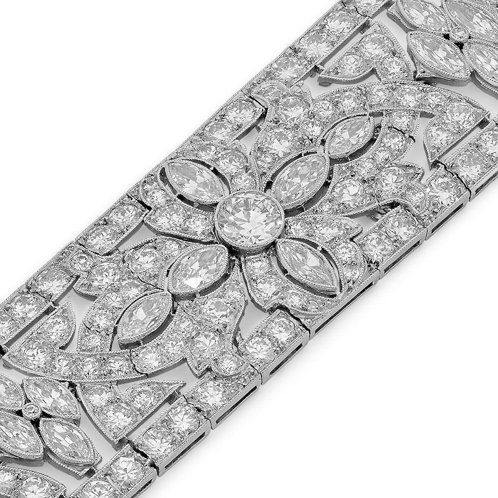 1920's Art Deco Wide diamond platinum bracelet. 3/4 inch wide and 7 1/4 length.
Aprox 30 ct of diamond, a mixture of Round and Marquise shapes. The center diaond is 3/4 carat,  accompanied by 6 marquis shapes making the daisy design in the center