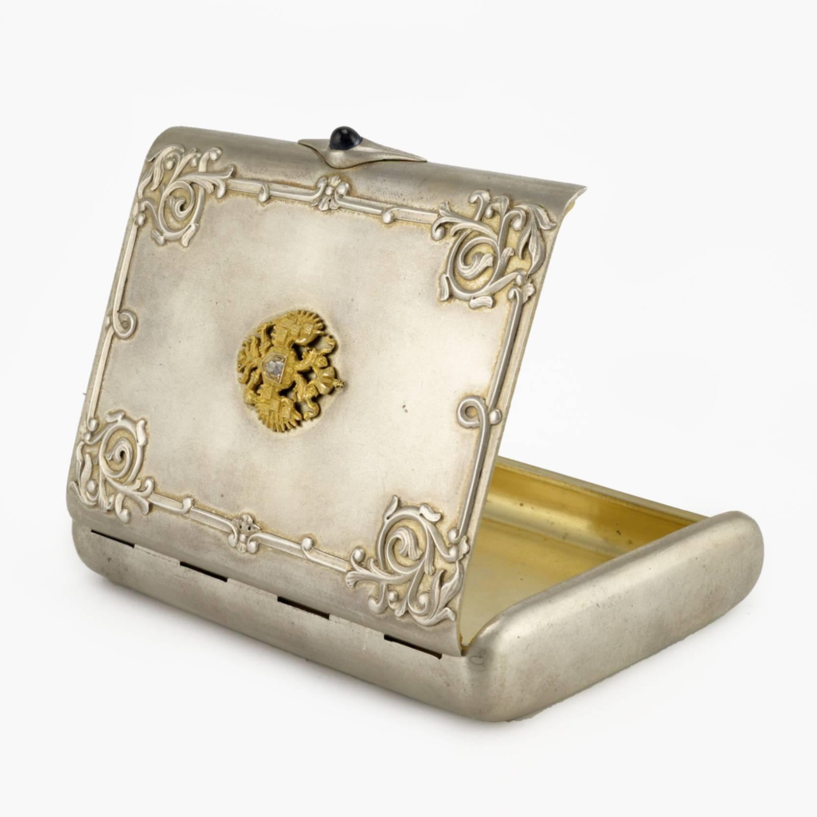 A Fabergé Imperial presentation jeweled silver cigarette case, workmaster Gabriel Niukkanen, St Petersburg, circa 1904-1908. Rounded rectangular, the hinged lid set with a scrolling foliate ornament in the Russian Style, centered with a gold