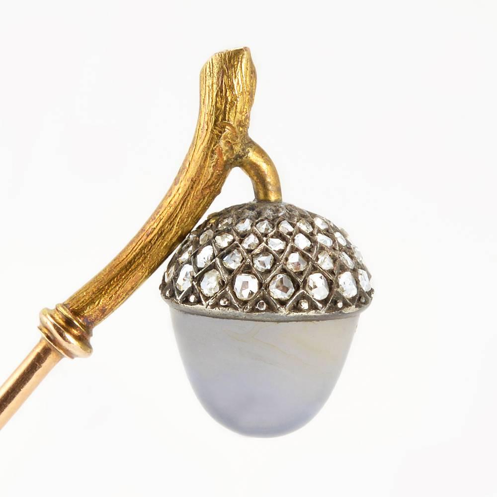 A Fabergé diamond-set gold and carved moonstone hat pin, workmaster August Hollming, ST Petersburg, 1904-1908. The Russian Imperial era jewel with finial formed as an acorn with a fine moonstone cabochon and a channeled silver cap set with numerous