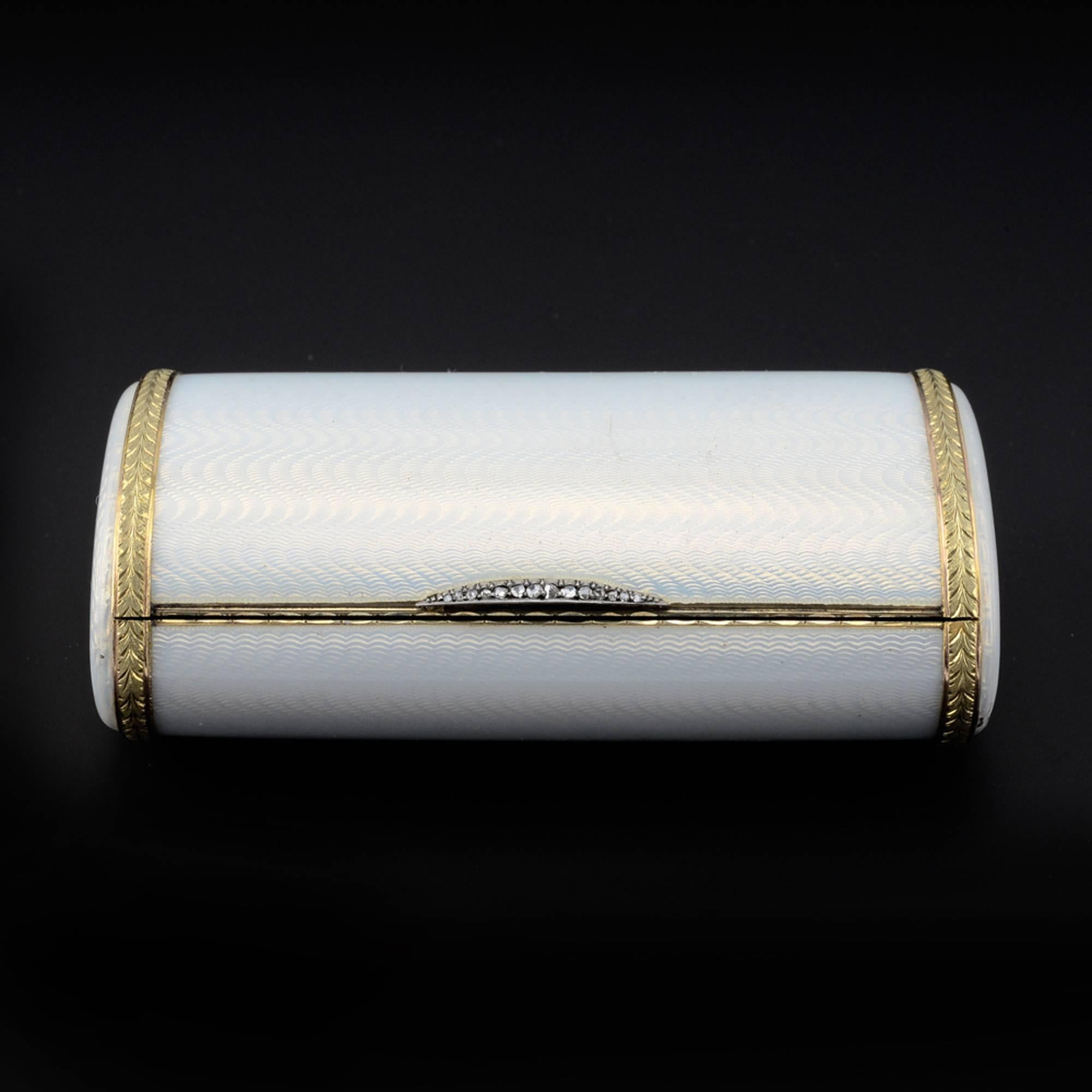 An elegant Fabergé jeweled varicolor gold-mounted gilded silver and guilloché enamel cigarette case, workmaster Henrik Wigström, ST Petersburg, circa 1904-1908. Of oval section, enameled translucent oyster white over a moiré engine-turned