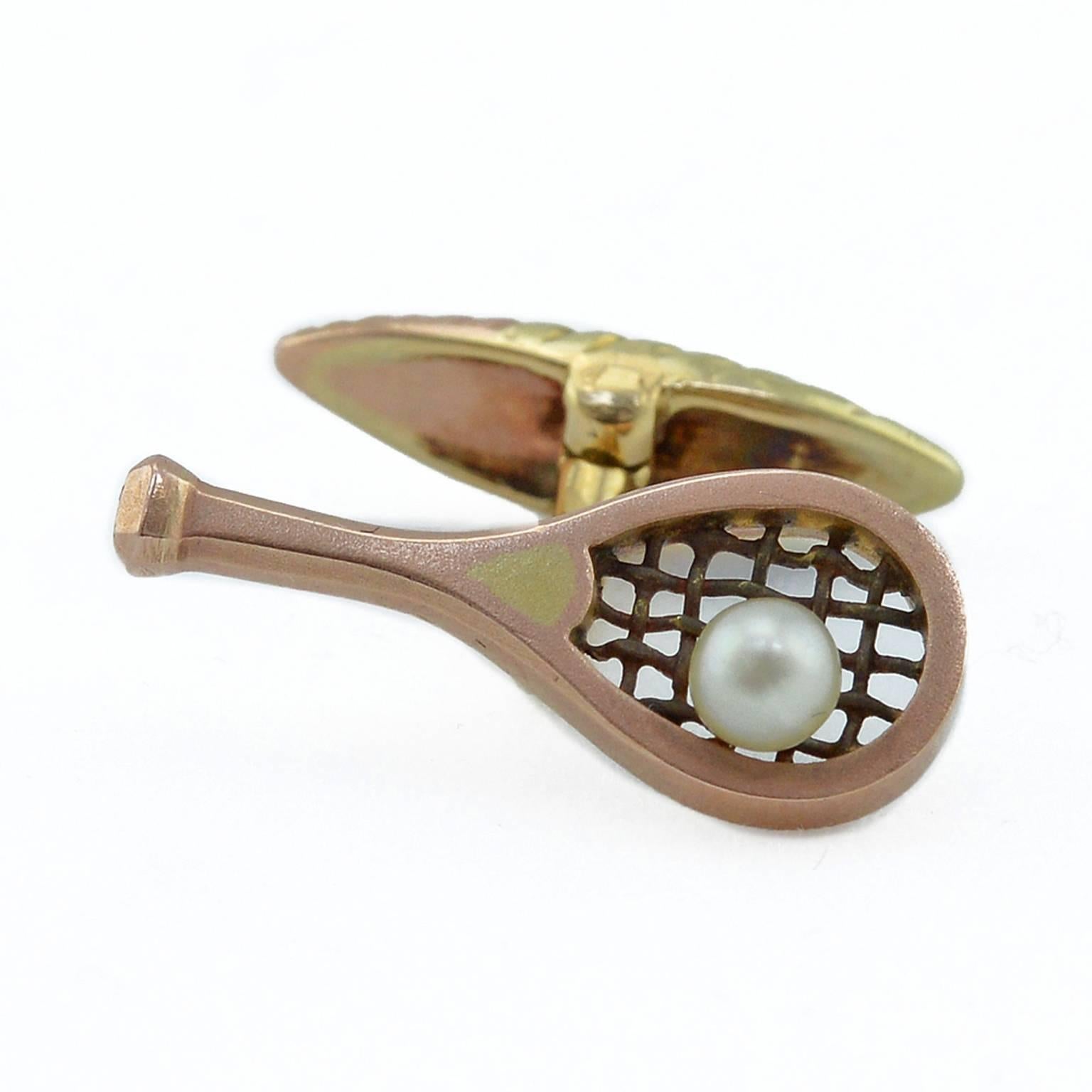 A pair of Russian varicolor gold and natural pearl cufflinks, Moscow, 1899-1908. The links formed as miniature rose gold tennis rackets, the black patinated gold strings set with a natural pearl in imitation of a tennis ball, the surface of the
