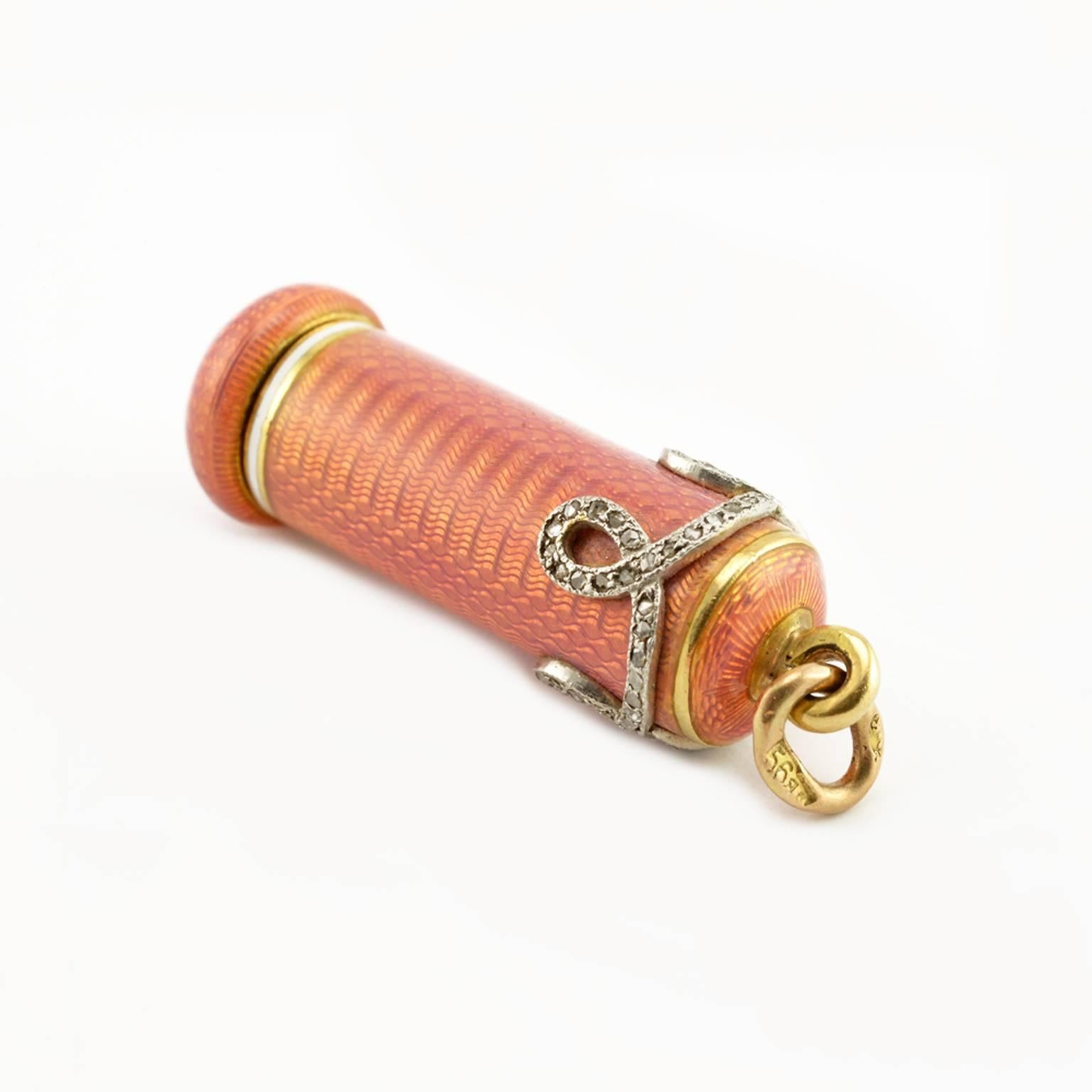 A Russian Imperial antique diamond-set gold and guilloché enamel retractable pencil, St. Petersburg, 1899-1904. The cylindrical body enameled rose pink over a wavy, engine-turned ground, the top with a band of diamond-set scrolls, a collar of opaque