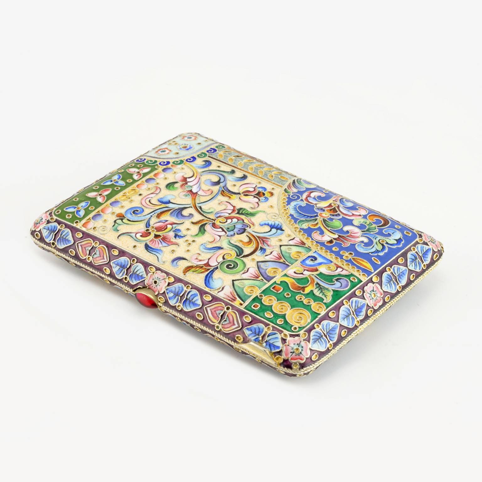 A Russian gilded silver and shaded cloisonné enamel cigarette case, Moscow, 1908-1914. Of rounded rectangle form, the exterior enameled on both sides with a central shaped rectangular reserve with brightly-colored stylized tulips and foliage against