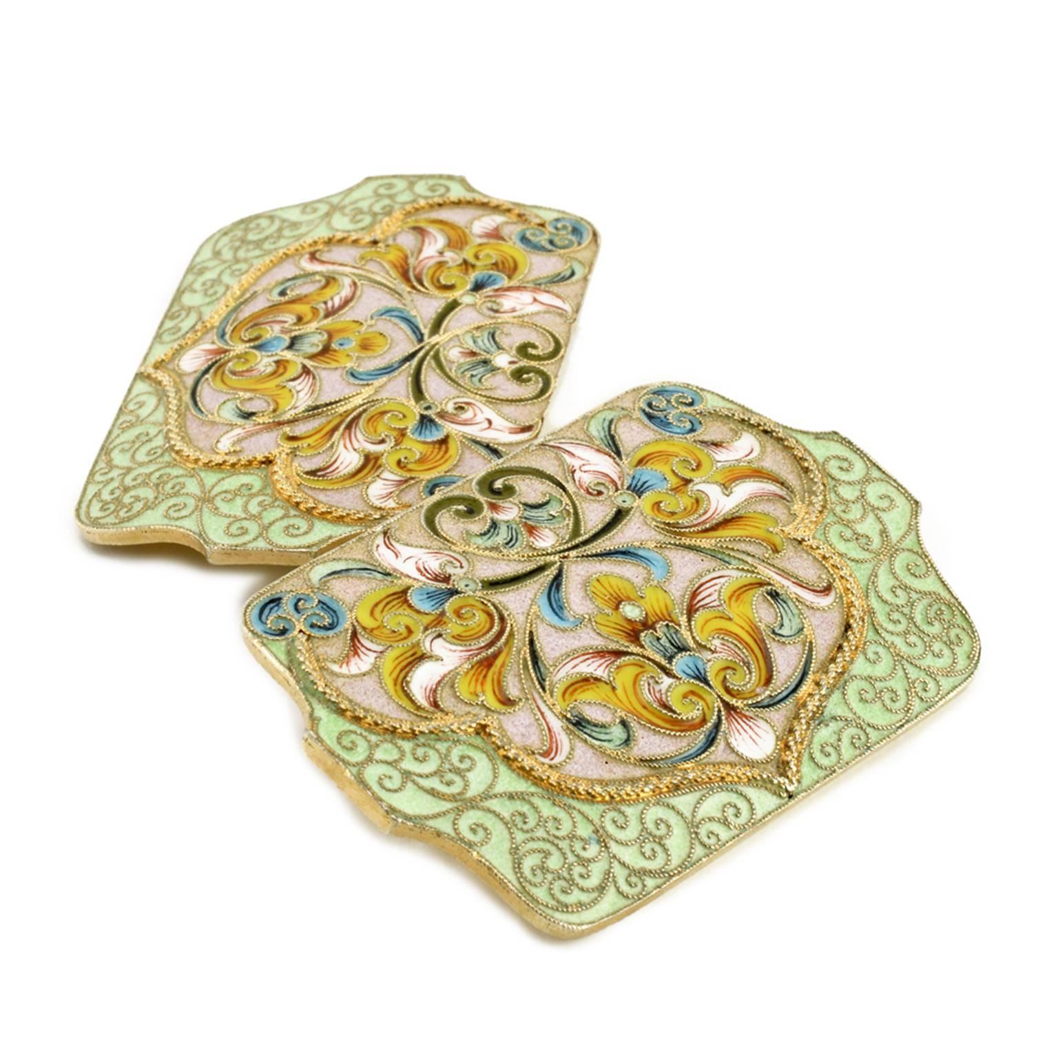 A Russian gilded silver and shaded cloisonné enamel belt buckle, Moscow, circa 1895. Shaped rectangular, enameled with brightly-colored stylized tulips and scrolling ornament against a duck’s egg pale mauve within an ogee-shaped cable border, all