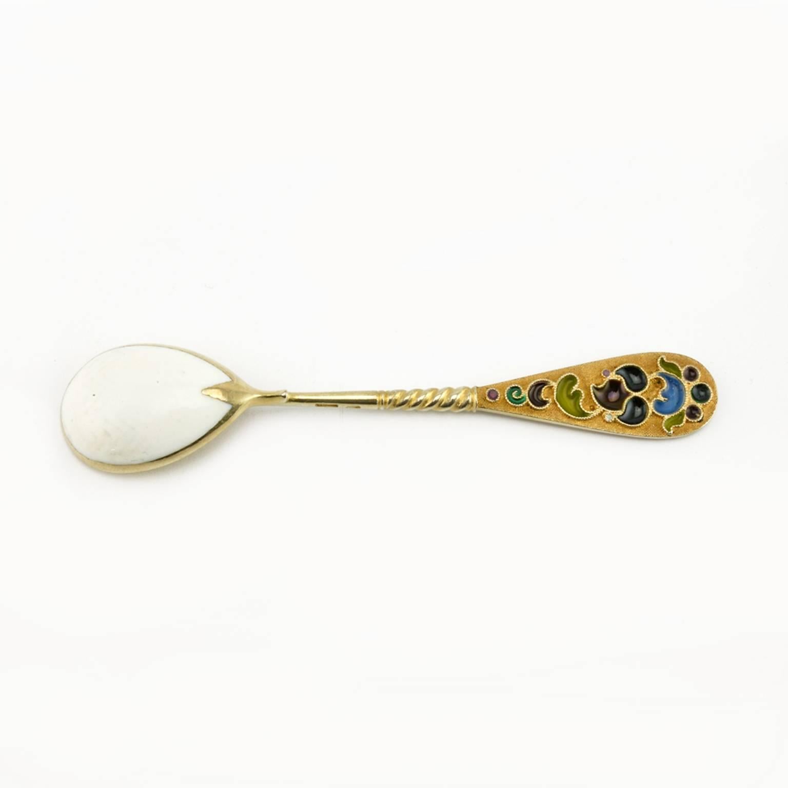 A set of twelve gilded silver and guilloché and plique-à-jour enamel demitasse spoons, 11th Artel, Moscow, 1908-1917, retailed by Tiffany & Co. The backs of the bowls enameled white over a herringbone, engine-turned ground, the interior of the bowls