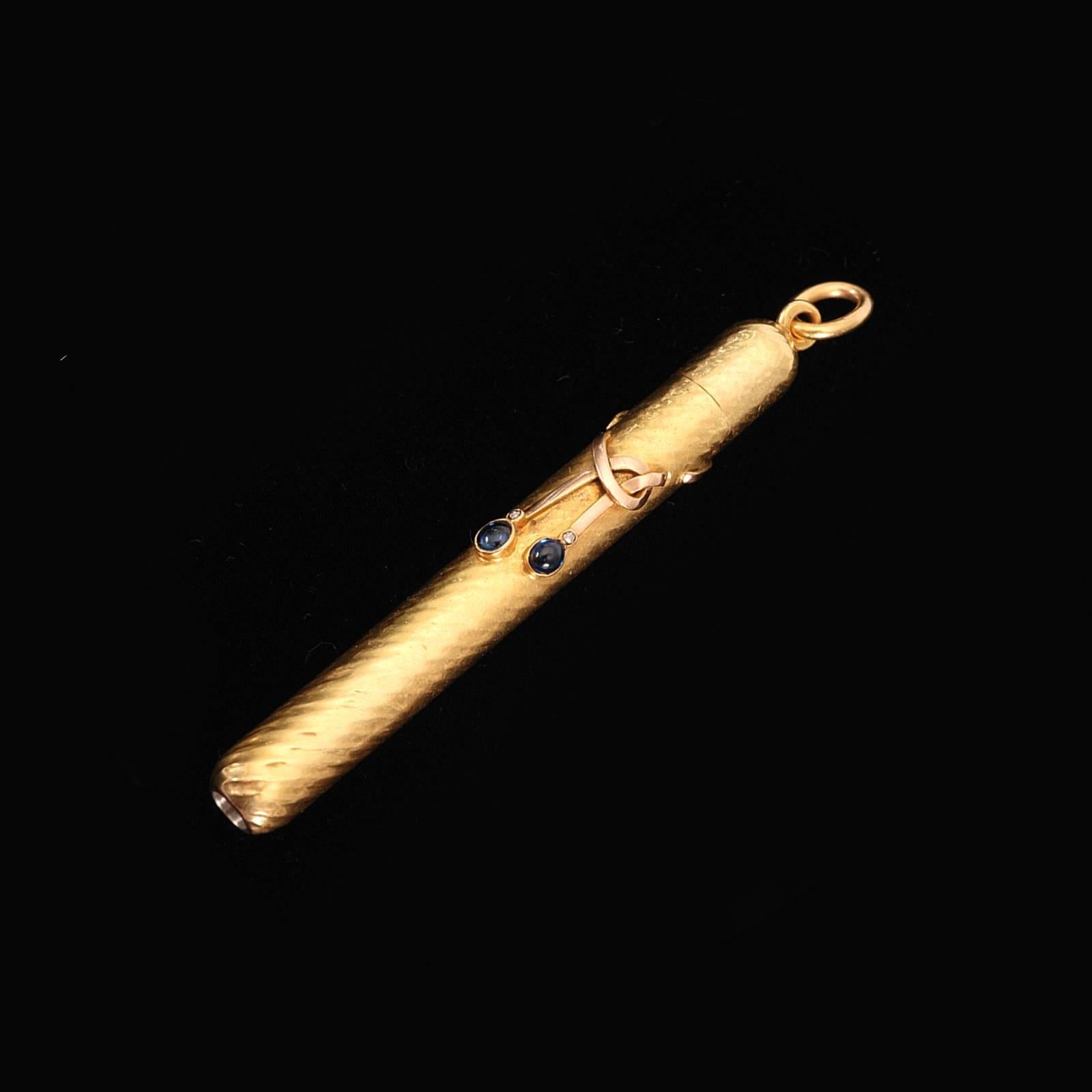 A Russian jeweled two-color gold retractable pencil by Nicholls and Plincke, Saint Petersburg, before 1880. The heavy gold pencil of cylindrical form with spiral fluting, having diamonds and cabochon sapphires suspended from it with rose gold