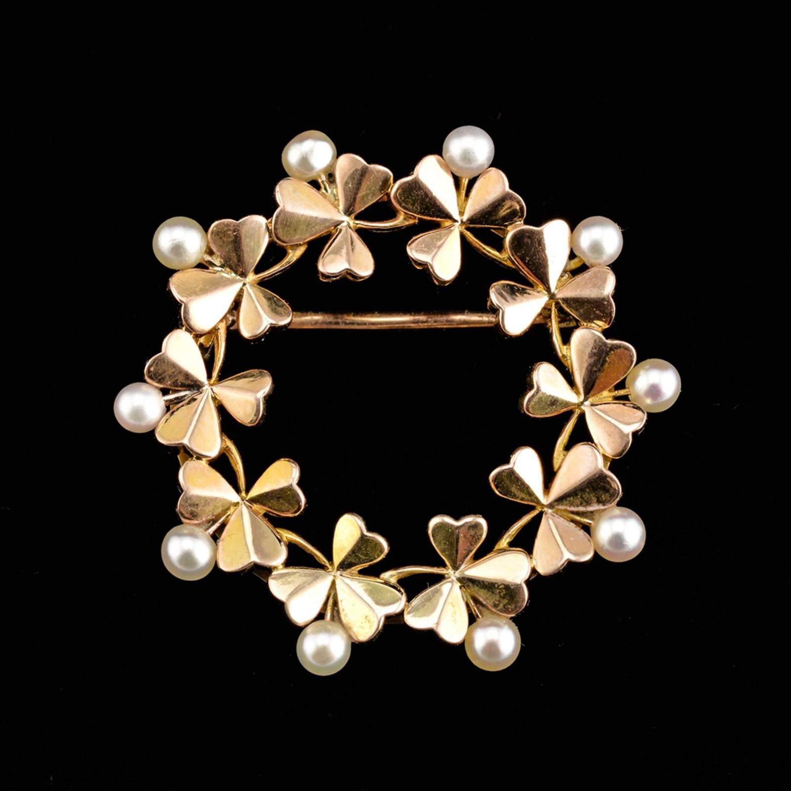 A Fabergé gold and pearl circular brooch, workmaster Wilhelm Reimer, St. Petersburg, circa 1890, with Fabergé scratched inventory number 1191 or 1611 and 36365. The circular gold brooch formed as a wreath of ten three-leaf clover, with pearls set