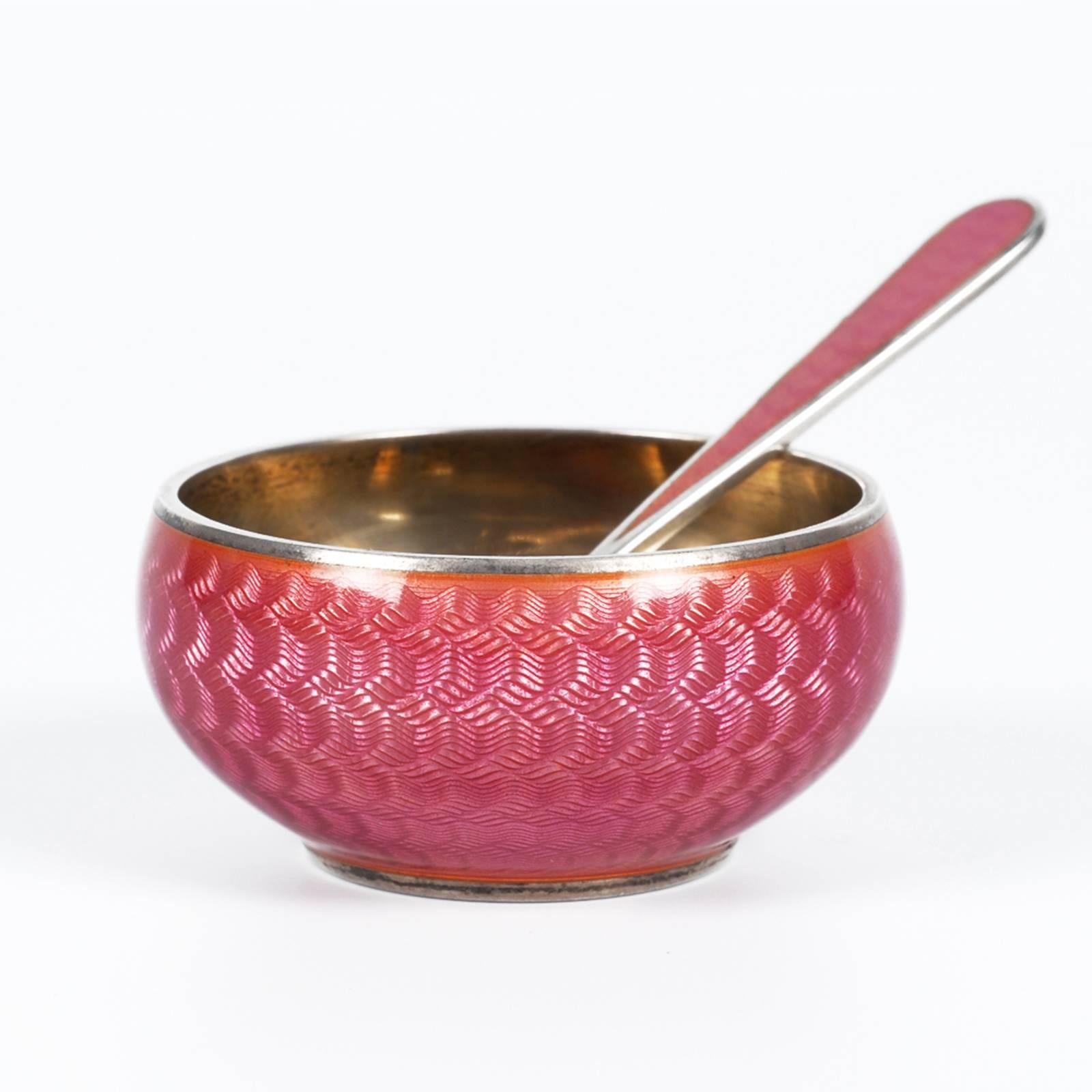 A Russian silver gilt and guilloché enamel open salt with matching spoon, Grachev, St. Petersburg, circa 1899-1903. Of circular form, the exterior of the body enameled in a raspberry pink translucent enamel over an engine turned ground, the back of