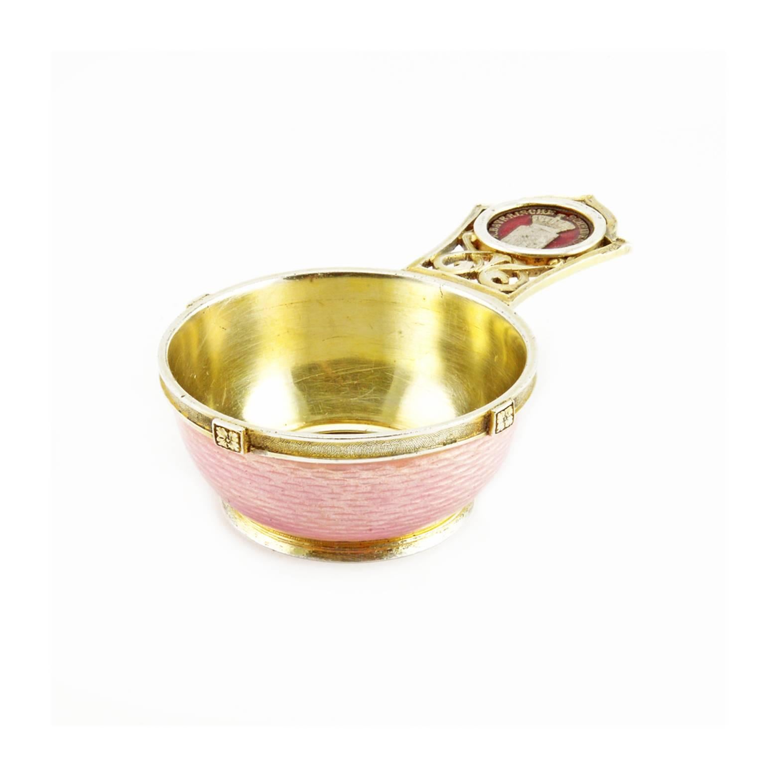 A Russian gilded silver and guilloché enamel miniature kovsh with coins, Saint Petersburg, 1904-1908. Of traditional shape, the exterior of the bowl enameled a pale translucent pink over an engine-turned ground, the interior of the bowl set with a