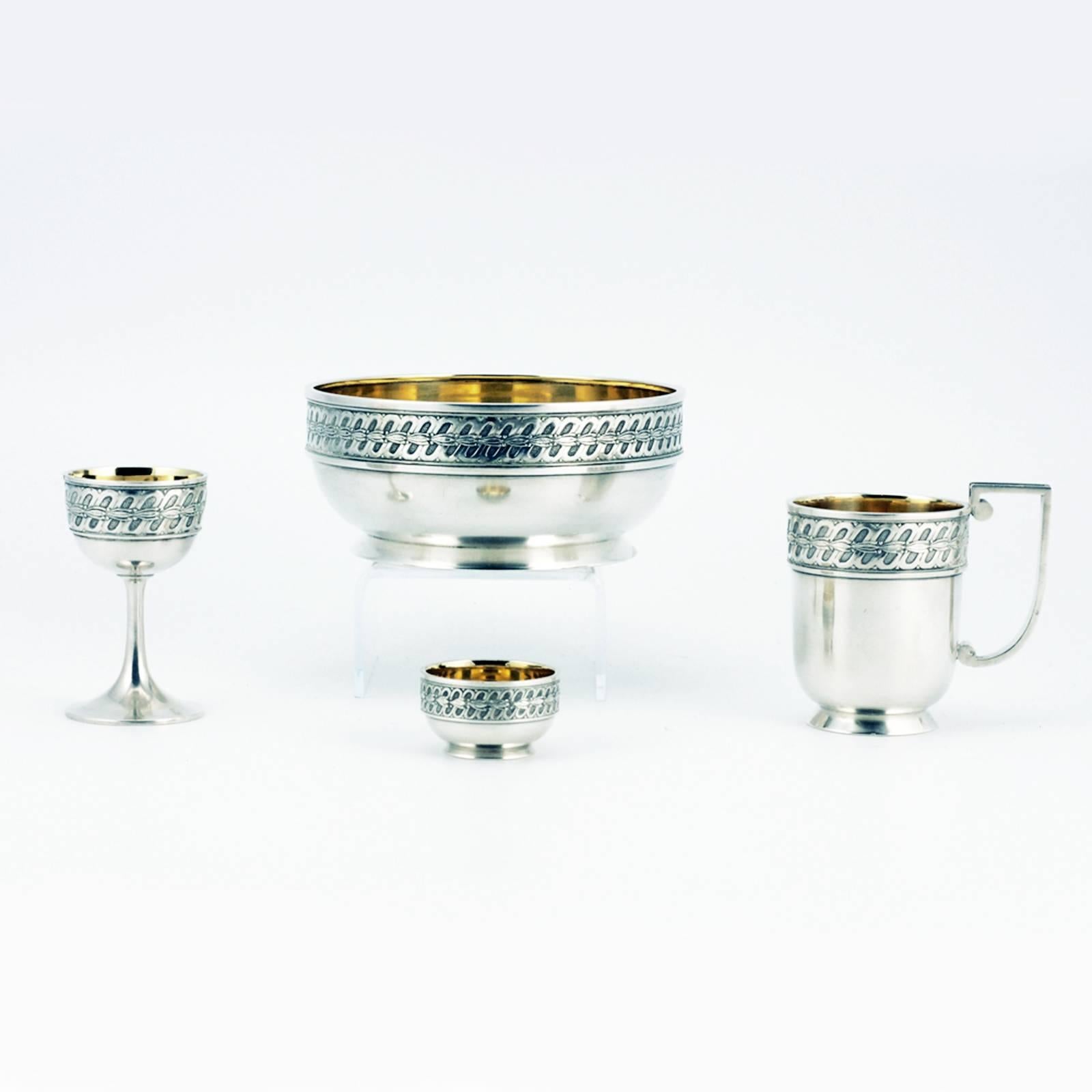 A Fabergé silver parcel gilt dining set for one, Moscow, circa 1908-1917. The set, known as an egoist in Russian because it was intended for solitary dining during travel, comprising a tea glass holder, bowl, liqueur glass, and open salt in