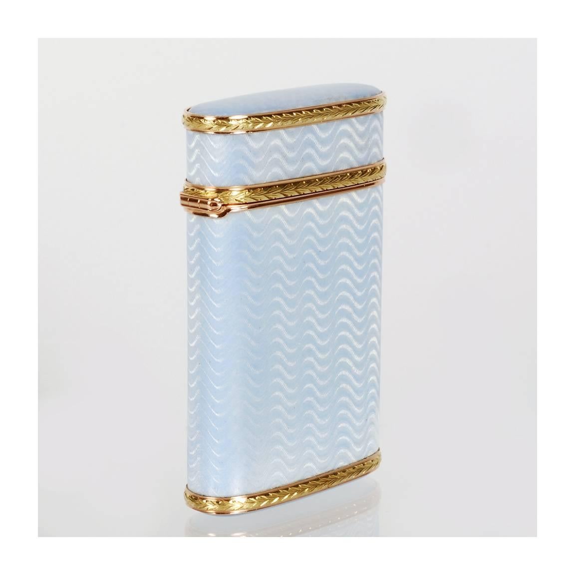 A Russian two-color gold mounted silver and guilloché enamel cigarette case by Andrei Adler, retailed by the firm of Sumin, St. Petersburg, 1908-1913. The case of upright oval form with hinged lid, enameled pale blue translucent enamel over a wavy