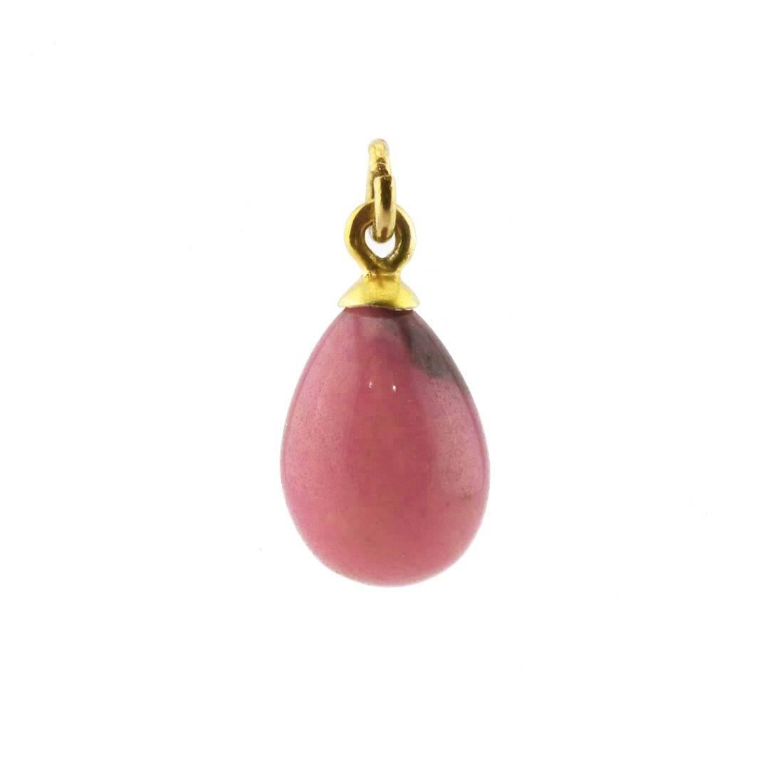 A Russian gilded silver and intense pink rhodonite miniature pendant Easter egg, circa 1900. The egg carved and polished of finely figured rhodonite, set with a gilded silver cap and suspension ring, the suspension ring struck with 84 silver