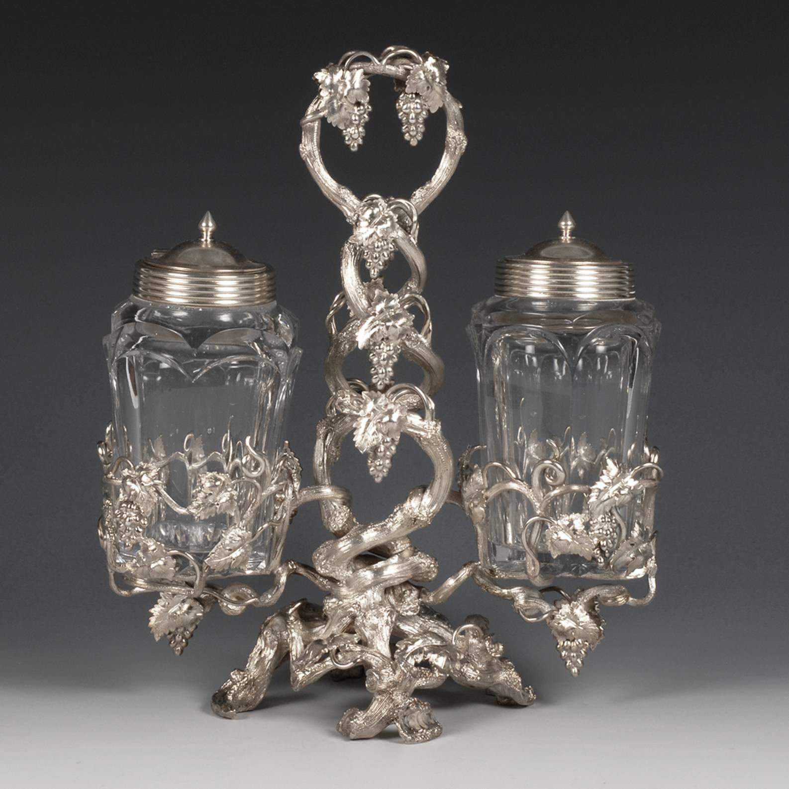 A Russian silver-mounted cut glass condiment set, Saint Petersburg, circa 1852. The mounts naturalistically cast and chased as entwined grapevines, on four feet shaped as leafy vines, with tendrils and bunches of grapes woven throughout and forming