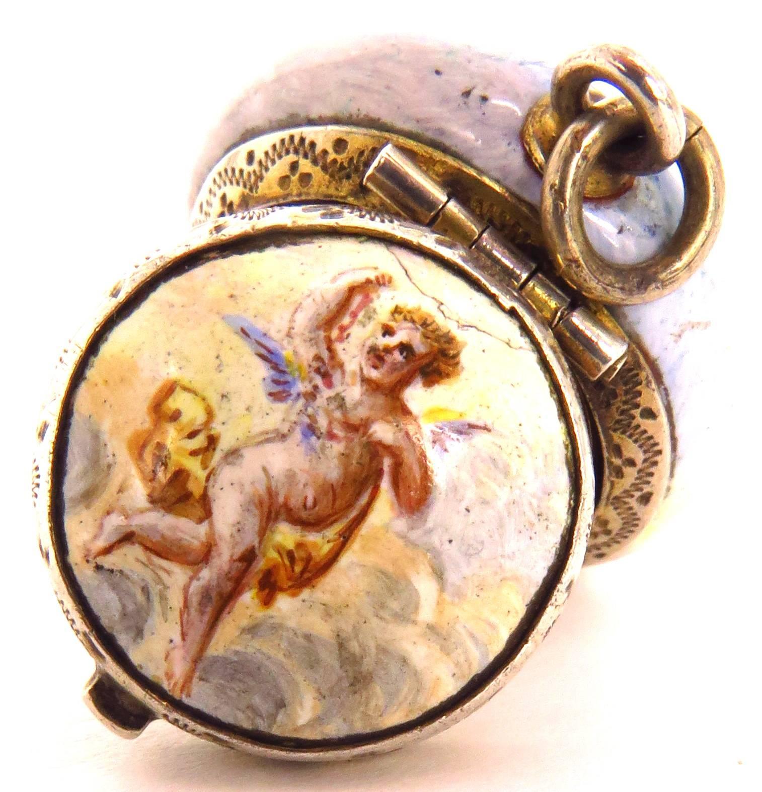 This wonderful porcelain vinaigrette has such a flow to it!. It's shaped like a miniature powder jar. The cover portrays a dog running with an angel. The bottom portrays 2 angels, one holding a lyre. When opened, the inside cover depicts a rose. The