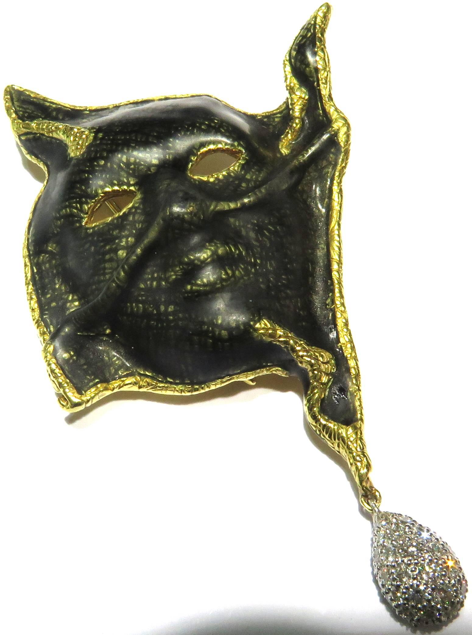 18k Platinum signed Cummings very unique enamel mask pin with platinum diamond ball drop. This Angela Cummings pin is dated 1999. It depicts a carnival mask, suspending a platinum diamond drop ball. This is the most interesting enamel in the way