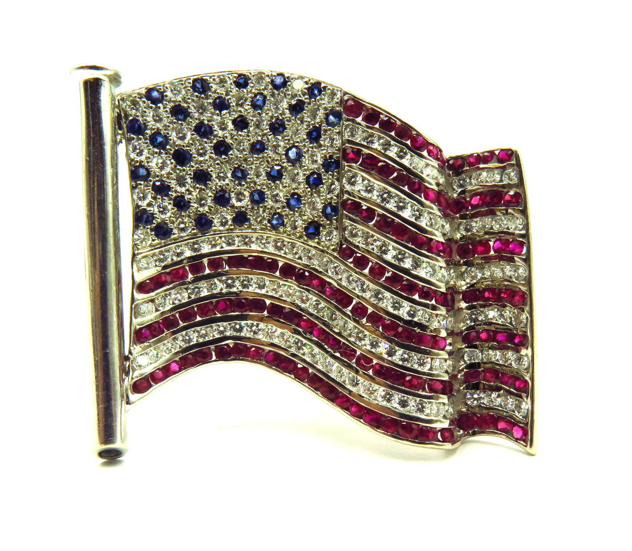 This well articulated flag pin looks like a flag blowing in the wind. 
Approximately 2.50ct of diamonds
Approximately 4ct of diamonds and sapphires
