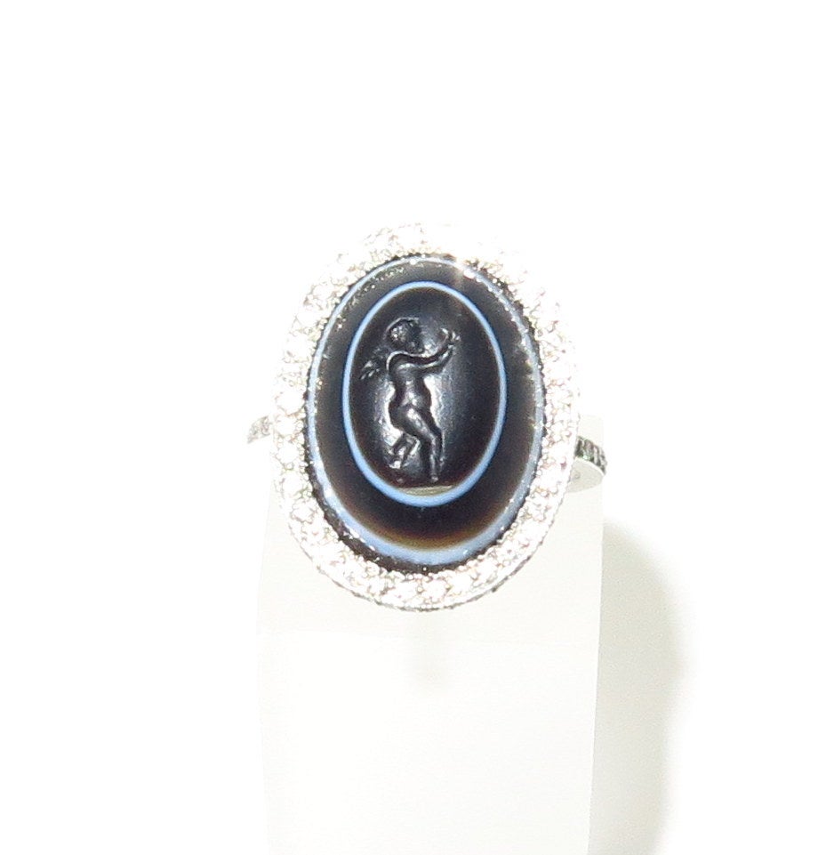 This stunning antique carved banded agate ring will have you admiring your hand all day.  It is set in a modern platinum diamond mounting which surrounds the antique angel seal beautifully. The marking on the inside of shank is Plat.  This ring is a