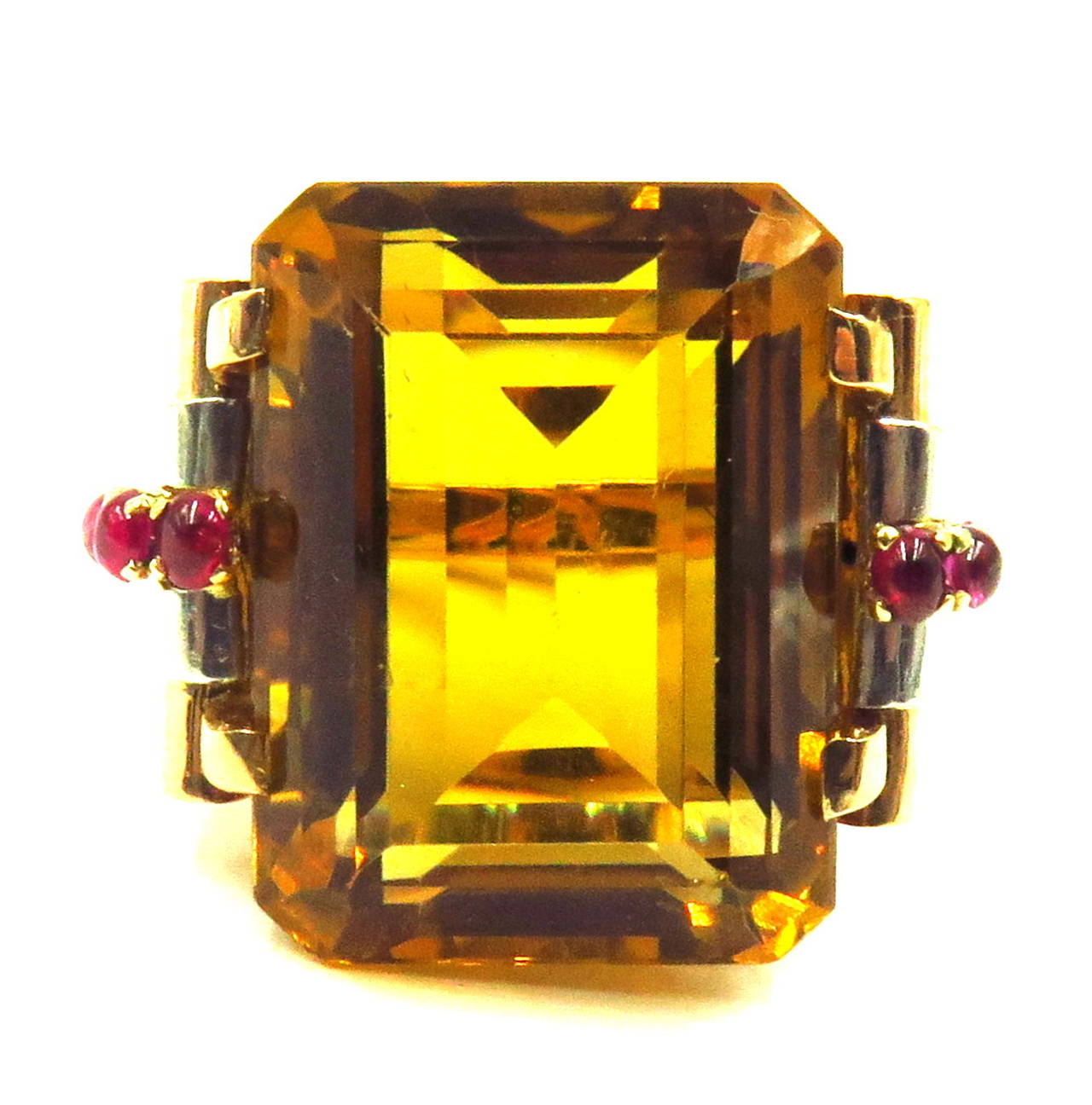 Exceptional example of a classic 1940's era ring. The mounting is in 14k rose gold with platinum accents to show off the 4 cabochon cut rubies on each side.
The citrine is a beautifully step cut stone approximately 30ct 
This ring is size 8. and