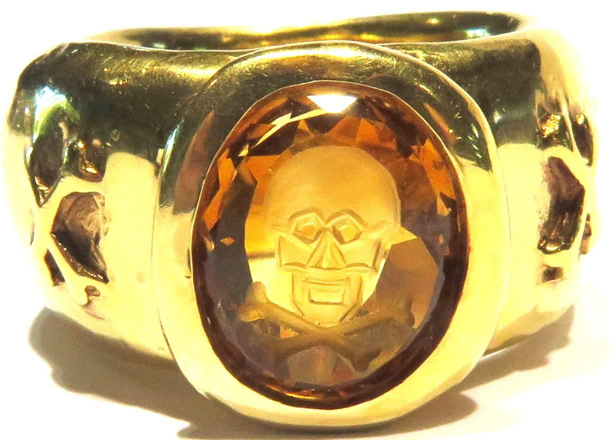 This magnificent Loree Rodkin ring can easily be worn by either a man or a woman. The skull & crossbones are deeply carved in citrine. On the sides of this very heavy 18K gold ring, are rustically detailed matching crossbones. I really love this