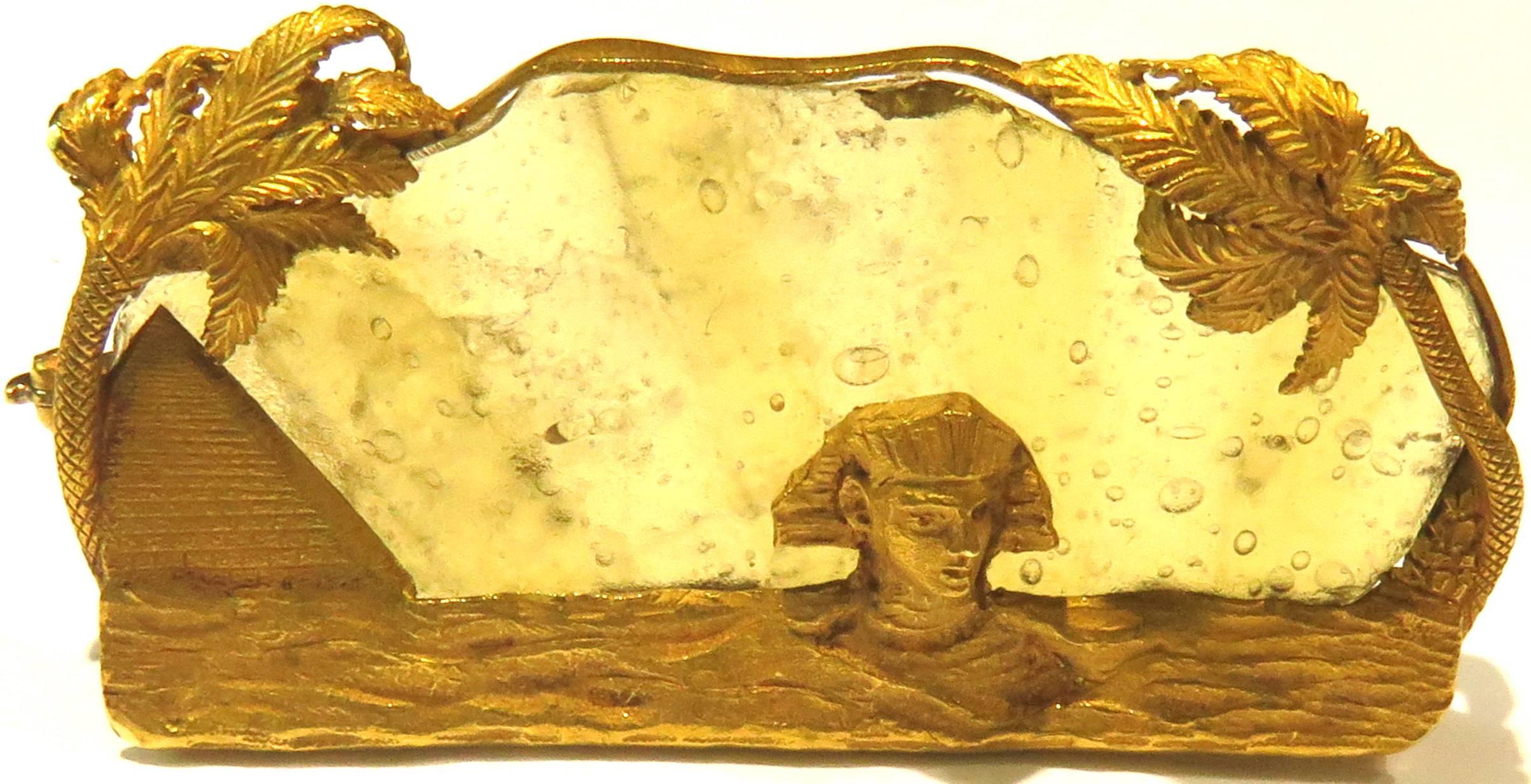 This gorgeous antique pin shows the Sphinx surrounded by 2 pyramids with draping palm trees while the sun risers. The gold tests 18k The detail is beyond incredible! The glass used in this pin is supposed to be ancient. I couldn't find any marks