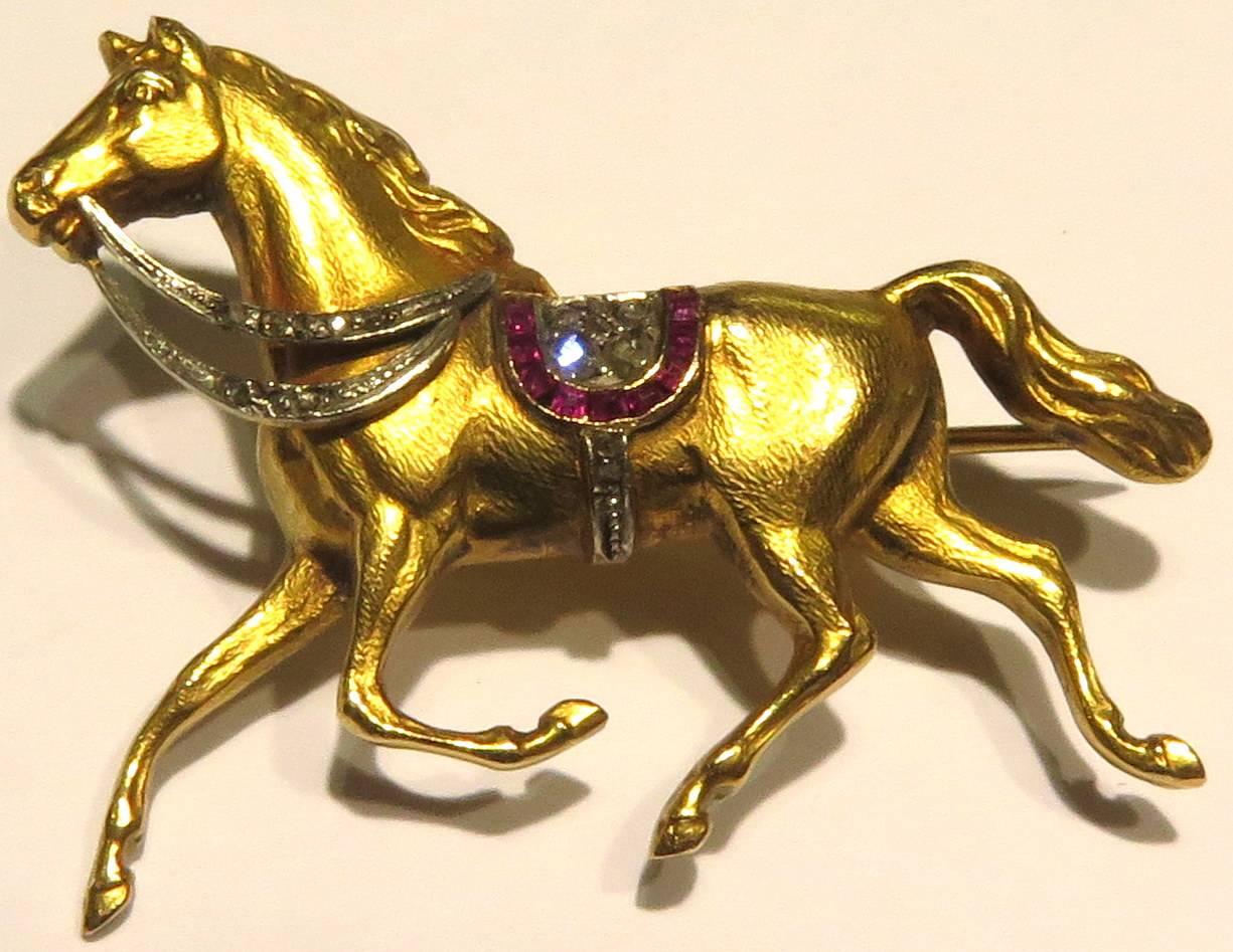 This wonderful 18k diamond ruby horse pin has incredible detail. This horse pin has rose cut diamonds and rubies to accent his reins & saddle. 
This pin measures 1 7/16 inch across by 1 1/8 inch high
This pin weighs 6.7 grams