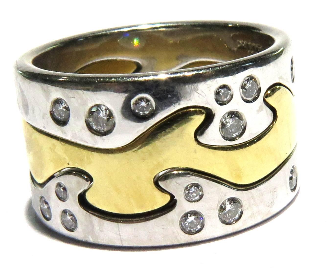 This Fusion ring by Nina Koppel for Georg Jensen can be worn by men or women. This puzzle type ring can be worn with 1, 2, or all 3 pieces. There are 2 18k white gold with scattered diamonds bands and 1 18k yellow gold band in the center. This bold