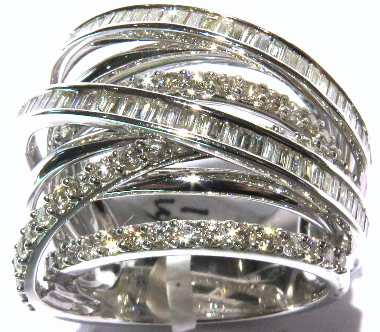 This chic 18k white gold ring is a show stopper. It looks fabulous! On the top half of the ring it looks like 9 bands, but the bottom inside shank is smooth. 
This ring is a size 7.
This ring weighs 16.8 grams
