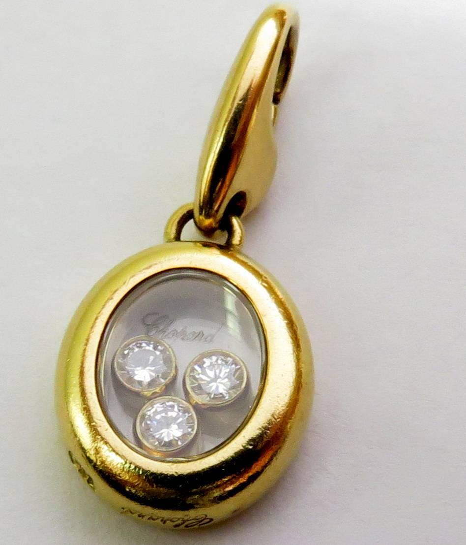 This classic Chopard 3 moving diamonds in oval shaped pendant or charm is easy to move from bracelet to necklace with it's original lobster claw bale. The diamonds are all VVS / F-G. You can see the name Chopard etched in the top of the glass and