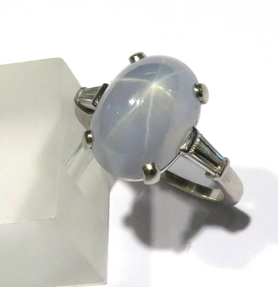 This elegant Raymond Yard ring is timeless. The rays of this wonderful star sapphire are sharp and clearly defined. Mounted in platinum with a single tapered baguette on each side, this ring is easy to wear everyday. 
This ring weighs 6.3 grams
This