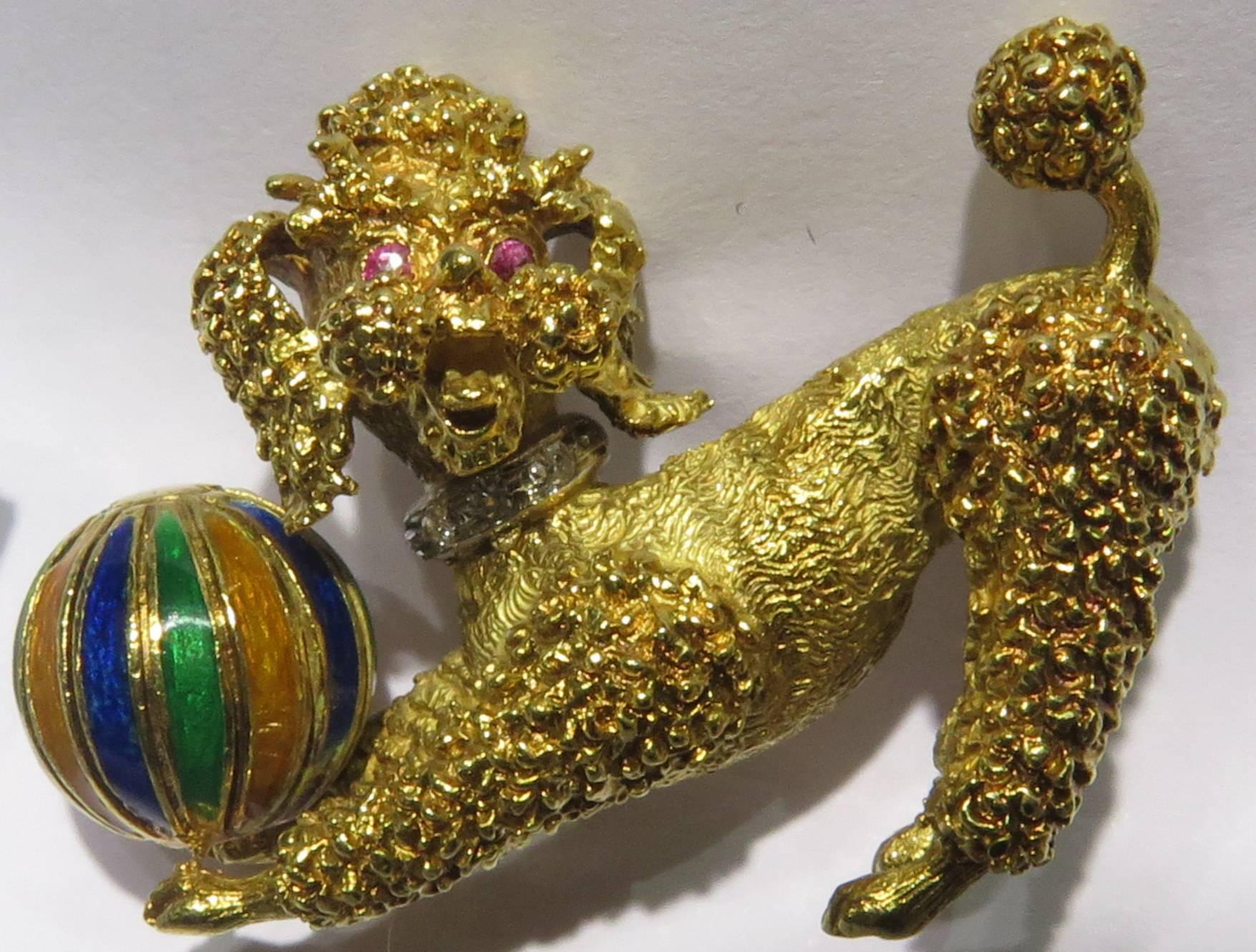 This playful little 18k gold chubby cheeked poodle pin has round faceted ruby eyes and a white gold diamond collar and has an attached green, blue and enamel ball that he loves playing with. This pin is numbered, but I can not find a signature on
