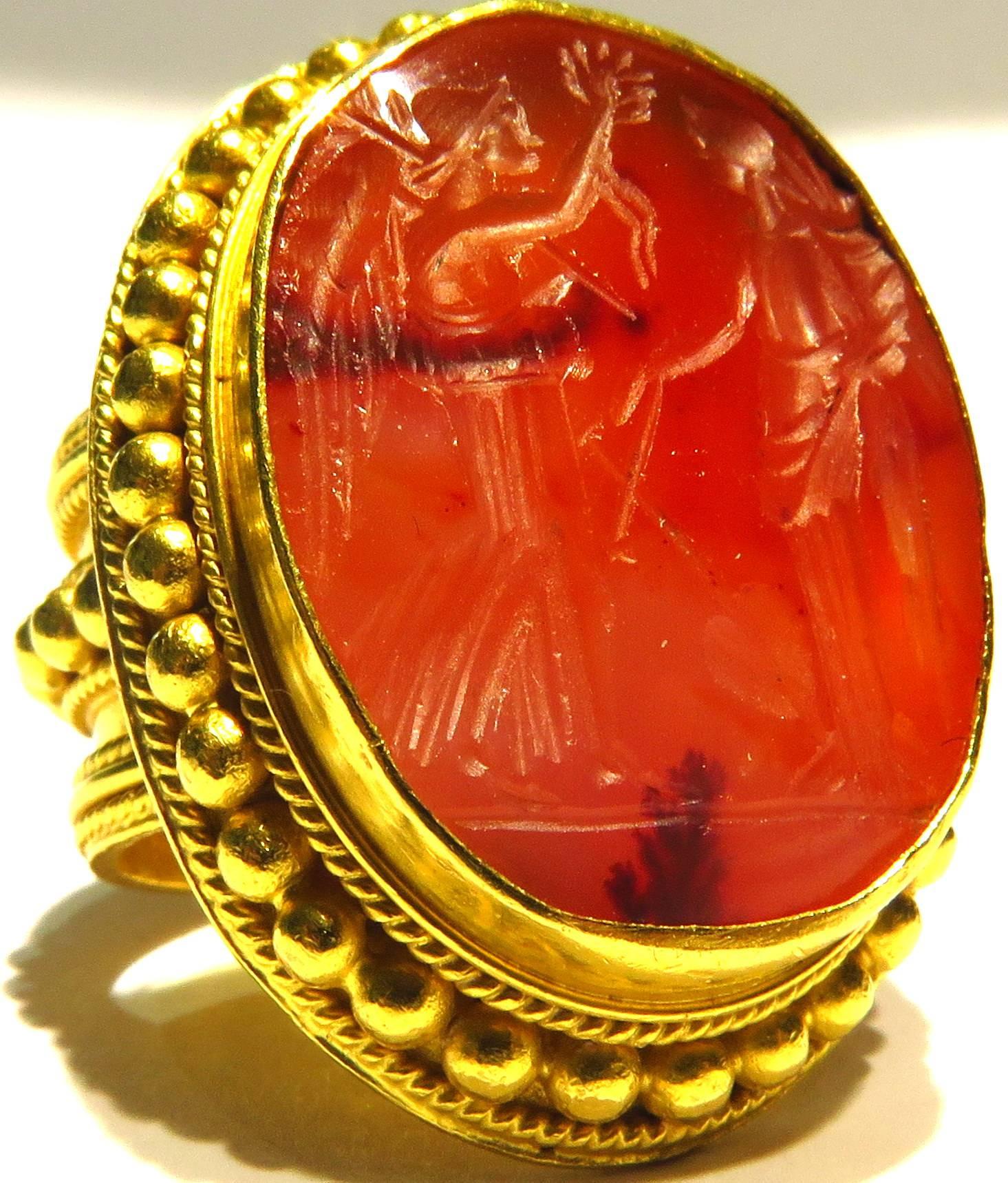 This is a very large exceptional antique seal ring mounted in 21K gold. There is a makers mark as shown in image 6 that I can not make out and on the other side, image # 7, is the 21K mark. The seal stone is a rare carnelian agate. The Etruscan