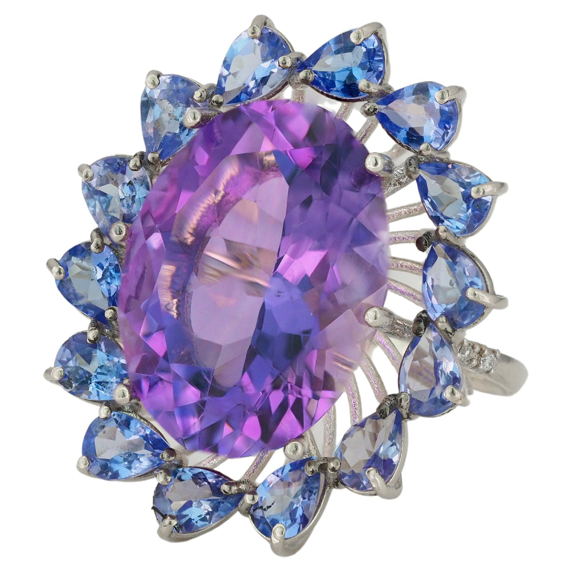 14 kt solid massive flower ring with natural amethyst, tanzanites and diamonds. February birthstone. December birthstone.
Weight approx. 10 g.

Central gemstone: Natural amethyst
Weight: approx 15.00 ct, oval cut, color violet
Clarity: Transparent